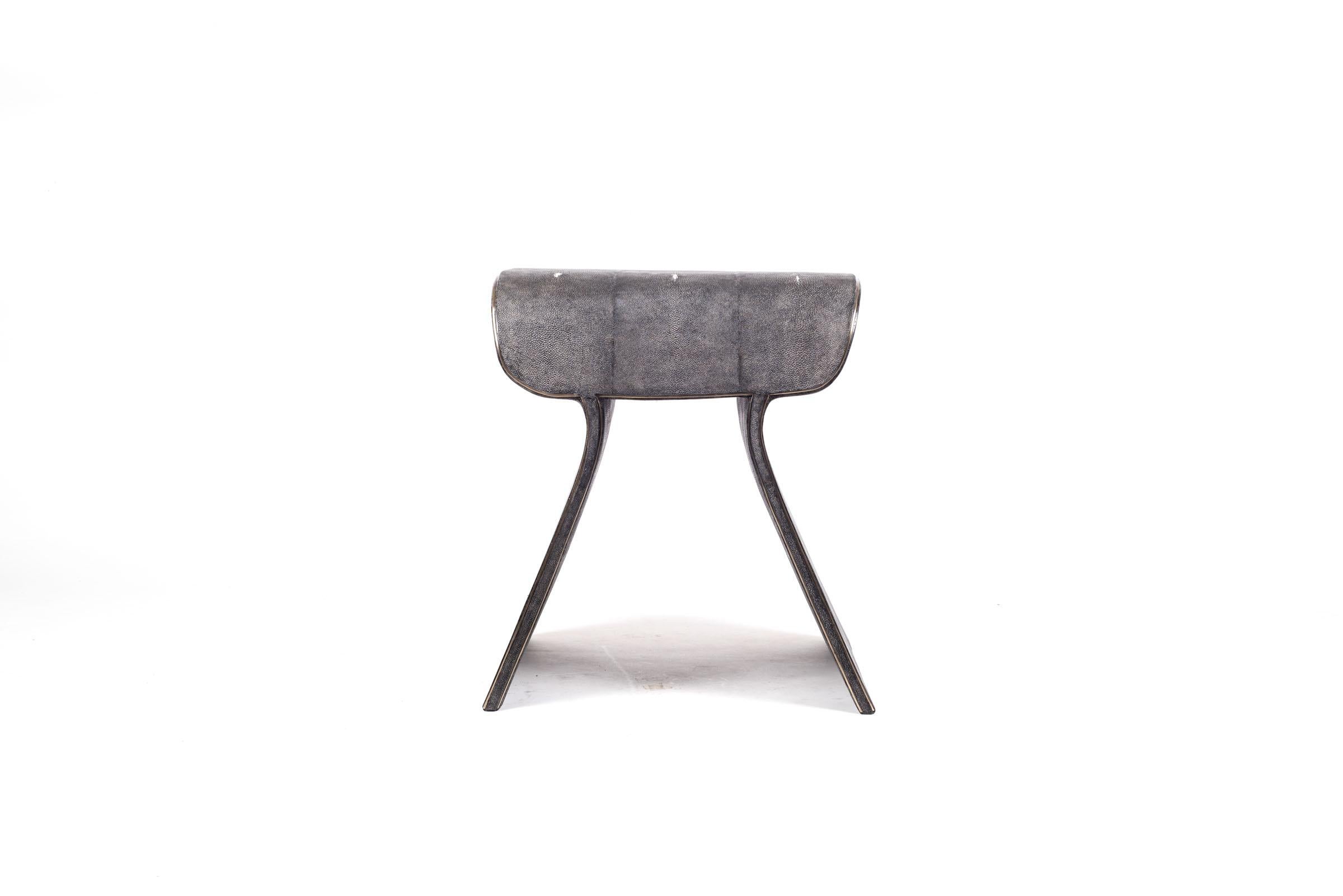 The dandy stool in coal black shagreen is a chic seating piece for any space. The clean lines make it an adaptable piece and the discreet bronze-patina brass indentation details add another luxurious element. Available with metal on the side, image