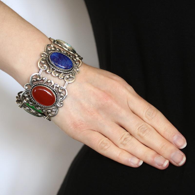 Define your style with this bold simulated multi-gemstone bracelet! Composed of sterling silver, this bracelet is fashioned in a striking link style that showcases five different simulated gemstones which are each set in beautiful open cut scroll