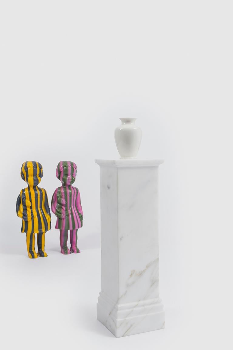 Pedestal Vase ist eine Serie von Miniaturvasen. Die archetypische Porzellanvase steht auf einem Sockel, der die doppelte Funktion hat, auch den Zylinder zu enthalten, der das Wasser aufnimmt. Die übertriebene Beziehung zwischen dem Sockel aus Holz