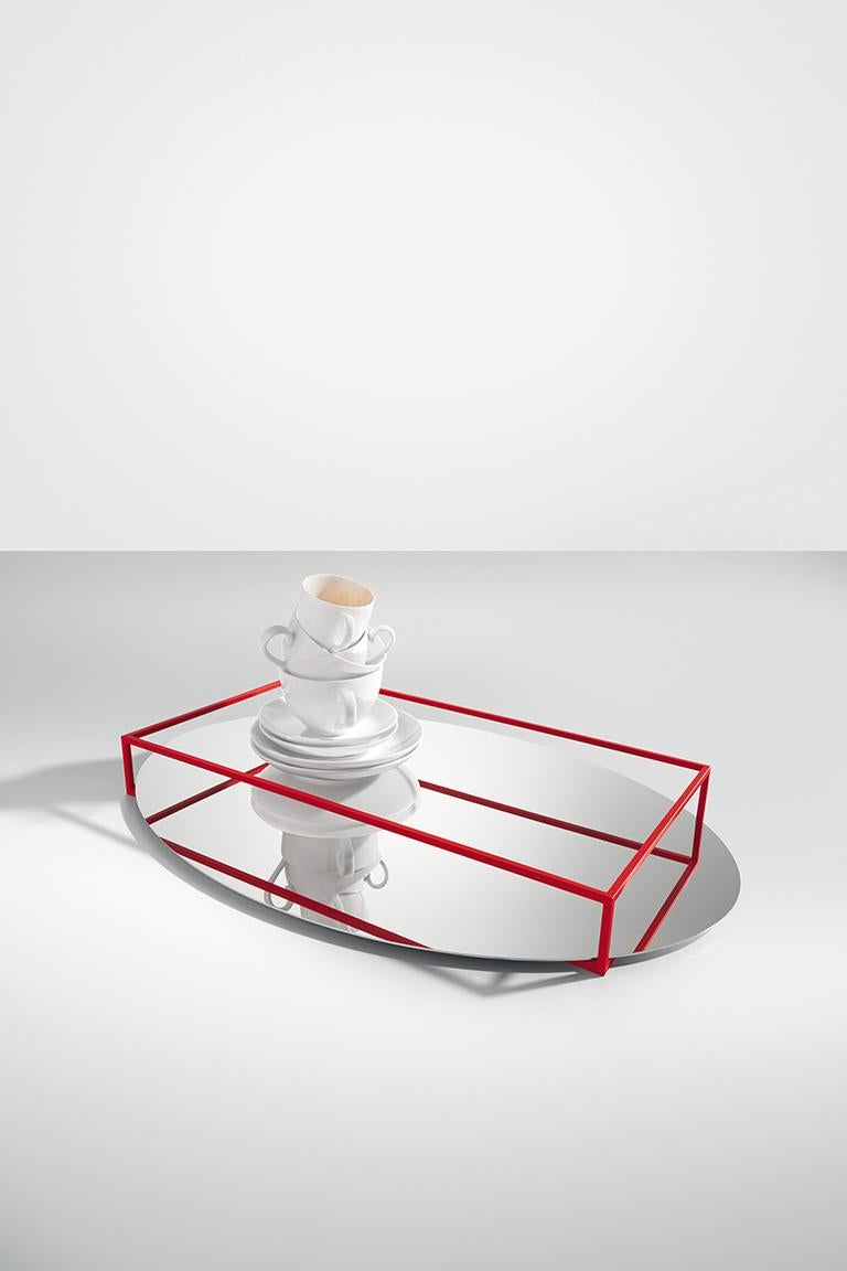 La surface e border no 2 est à la fois un plateau et une coupe à fruits. Le périmètre de la pièce est constitué de fines lignes de métal reposant sur un miroir ovale. La combinaison de ces éléments crée un jeu de reflets qui, à l'œil, semble