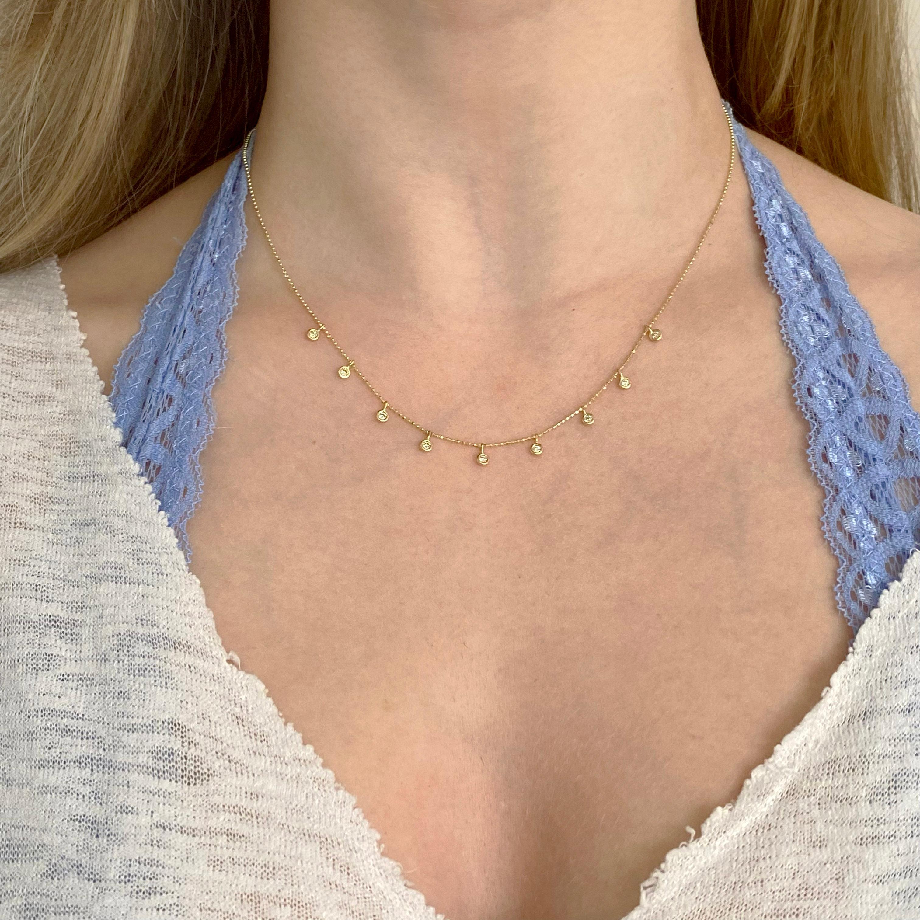 This 14 karat yellow gold diamond cut beaded chain looks stunning with the nine natural diamonds that are bezel set. The diamonds are individually set in a gorgeous bezel that are securely set and look like diamond fringe! Looking perfect as a