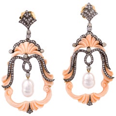 Orecchino pendente con conchiglia, cammeo e perla con pavé di diamanti, realizzato in oro e argento.
