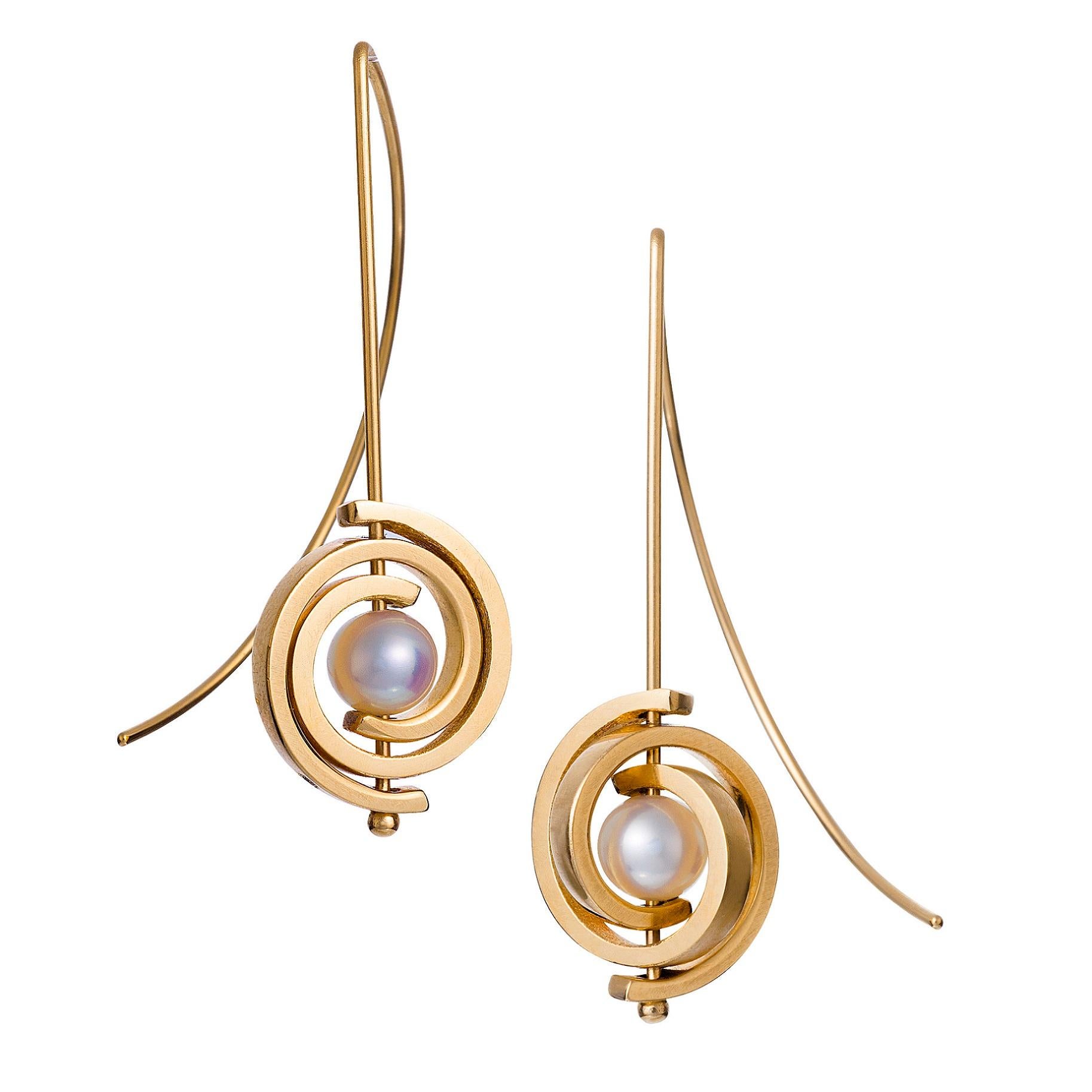 Ces  les boucles d'oreilles pendantes en perles de Tahiti font partie de la collection Orbit. Il s'agit de boucles d'oreilles en spirale de taille moyenne avec des spirales dorées et un fil d'oreille de calibre 20. Les perles rondes noires de Tahiti