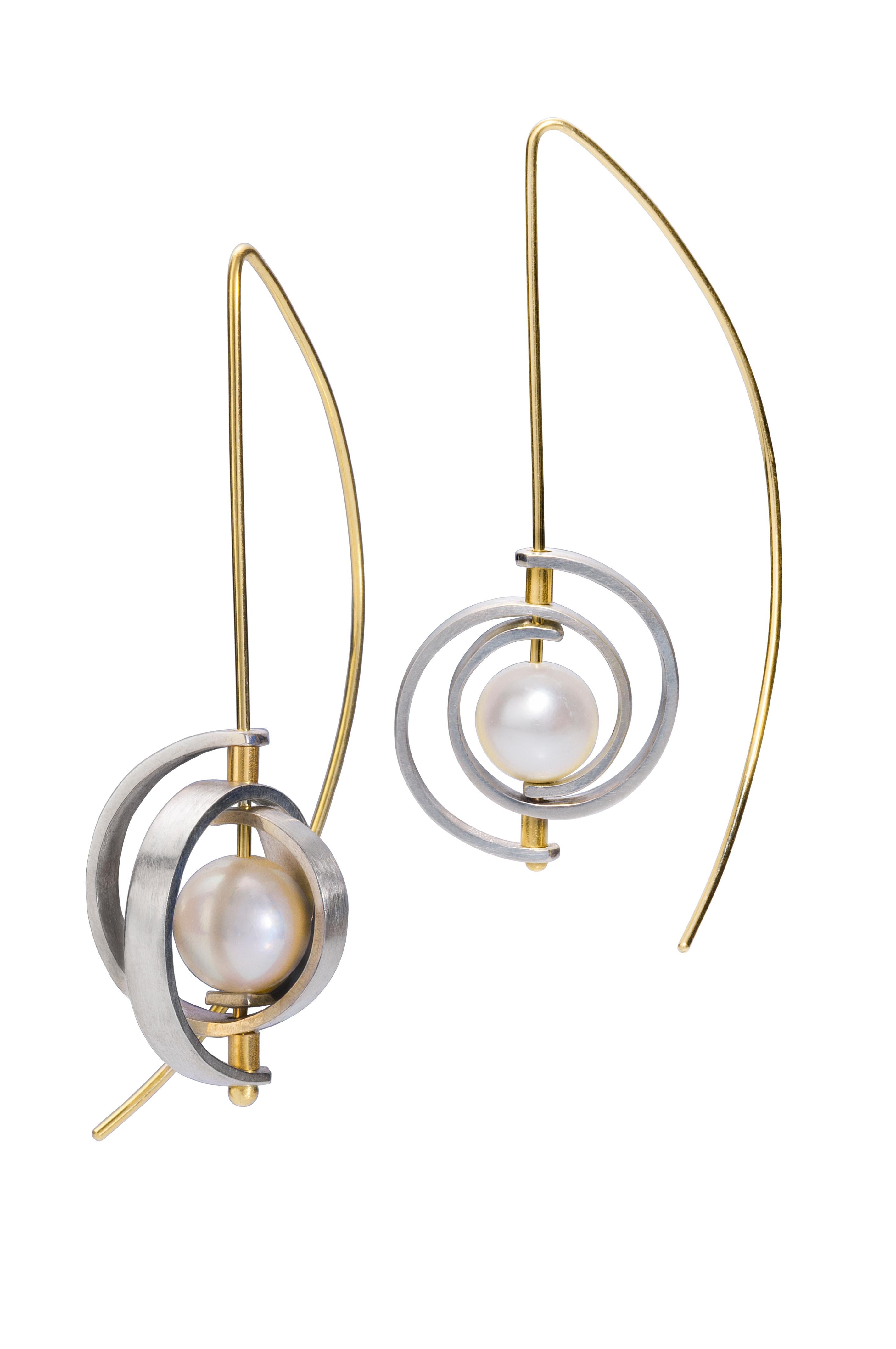 These pearl earrings are a modern classic. They are Medium Spiral Dangle Earrings from the Orbit collection with sterling silver spirals, a 21 gauge 14karat yellow gold ear wire and a lustrous, 7-8.5mm Akoya pearl. The earrings hang 2