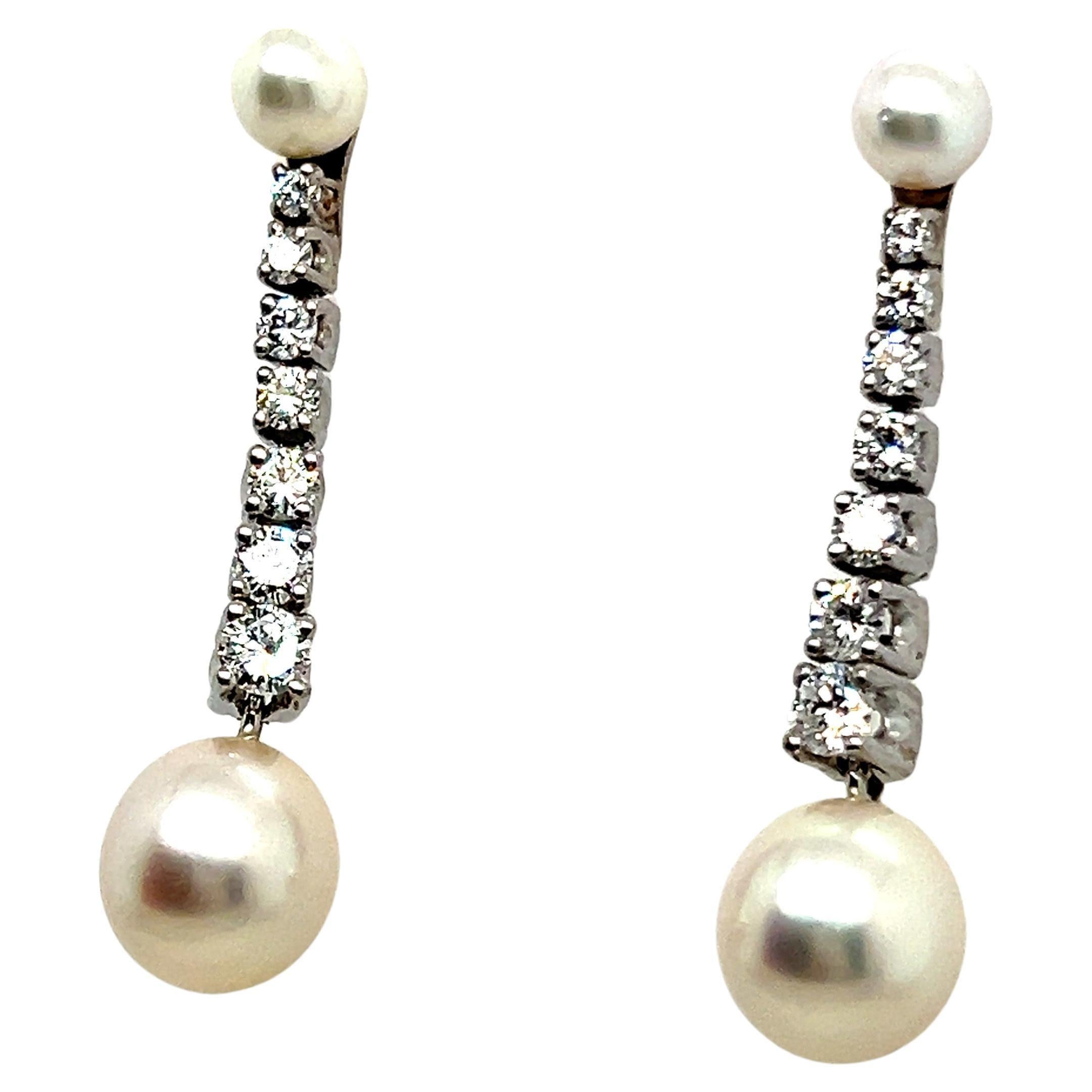 Discover the allure of our dangle earrings with pearls and diamonds, delicately fashioned in 18 Karat white gold. Adorned with 14 brilliant-cut diamonds totaling 1.05 carats, boasting G-H color and vs clarity, these charming bijoux radiate