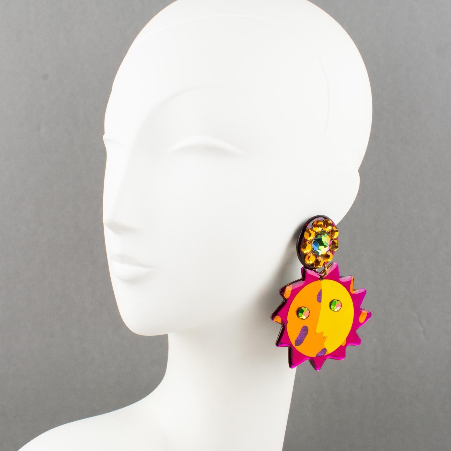 These stunning Italian designer studio Lucite or Resin dangling clip-on earrings feature an oversized stylized sun design shape with an incredibly playful and glittering textured pattern. The pieces boast an electrizing palette with fuchsia pink,