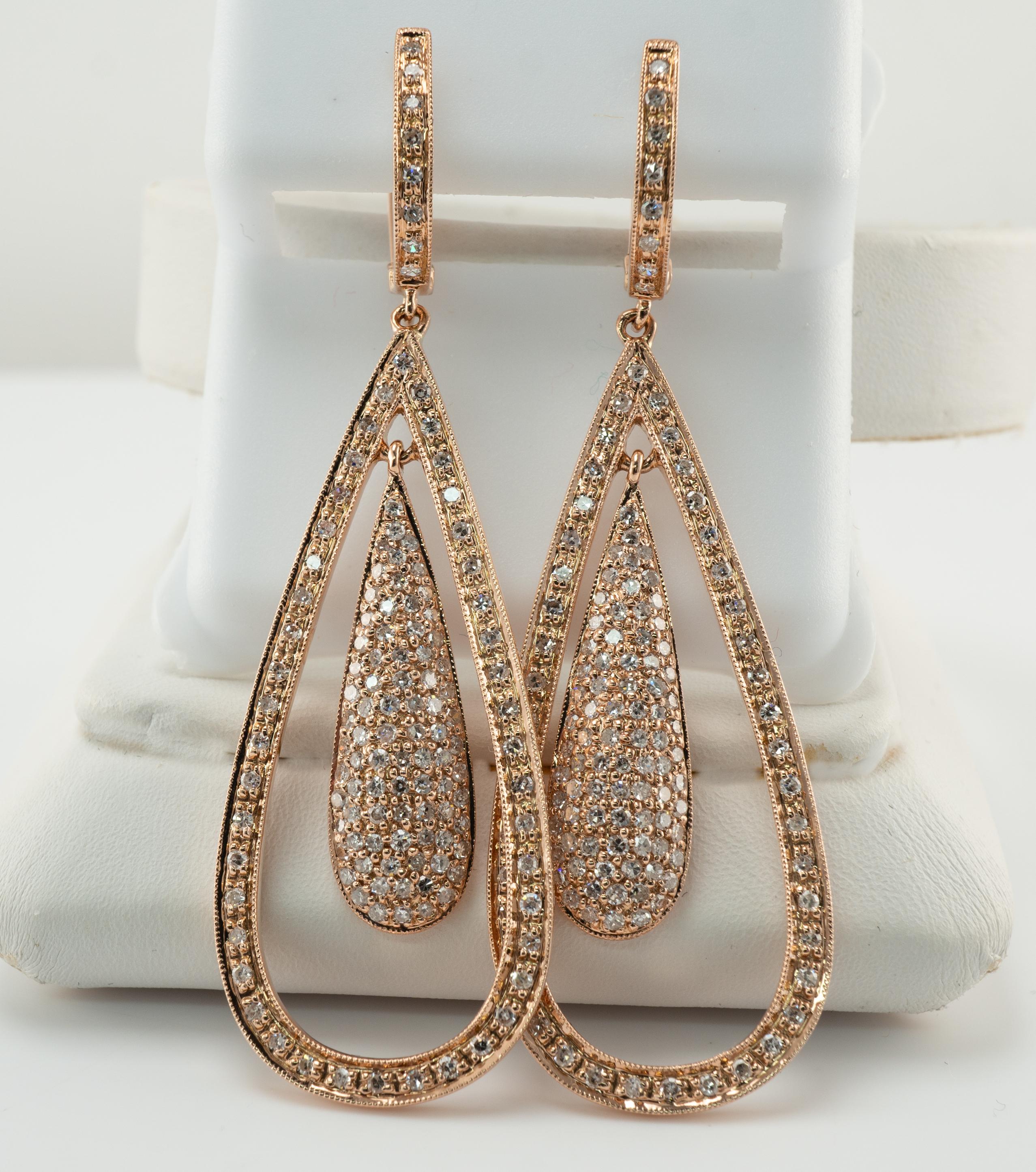 Dangle Natural Diamond Earrings 14K Rose Gold Teardrop 2.60 TDW

These estate earrings are crafted in solid 14K Rose Gold.
The earrings hold 130 diamonds in each earring = 260 diamonds for pair.
The total diamond weight for the pair is 2.60 carats