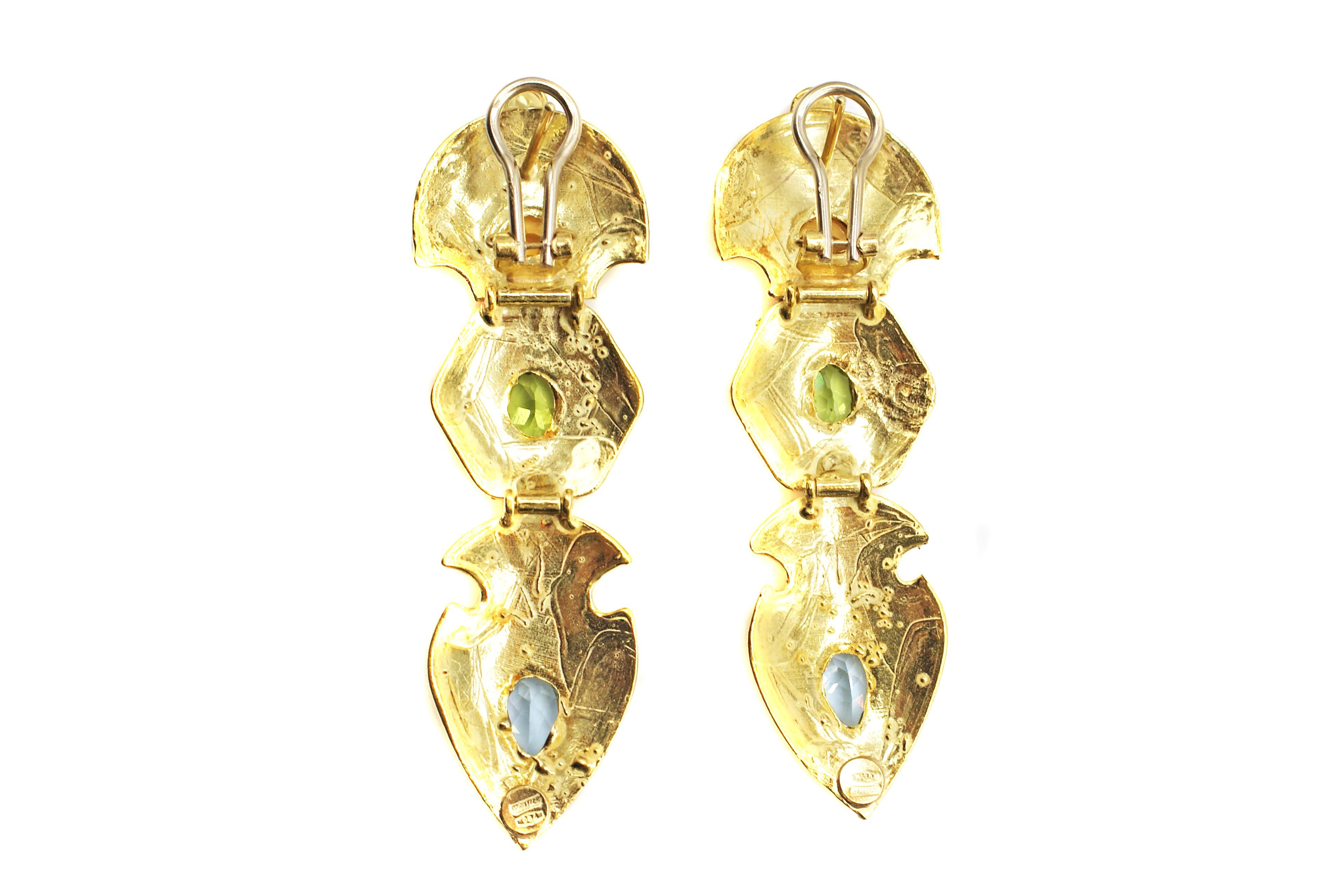 These extremely fashionable and fun dangling earrings have been masterfully designed to resemble the jewels from the Etruscan revival era. Three flexible plaques of 18 karat yellow gold have been beautifully engraved with a mat finish and