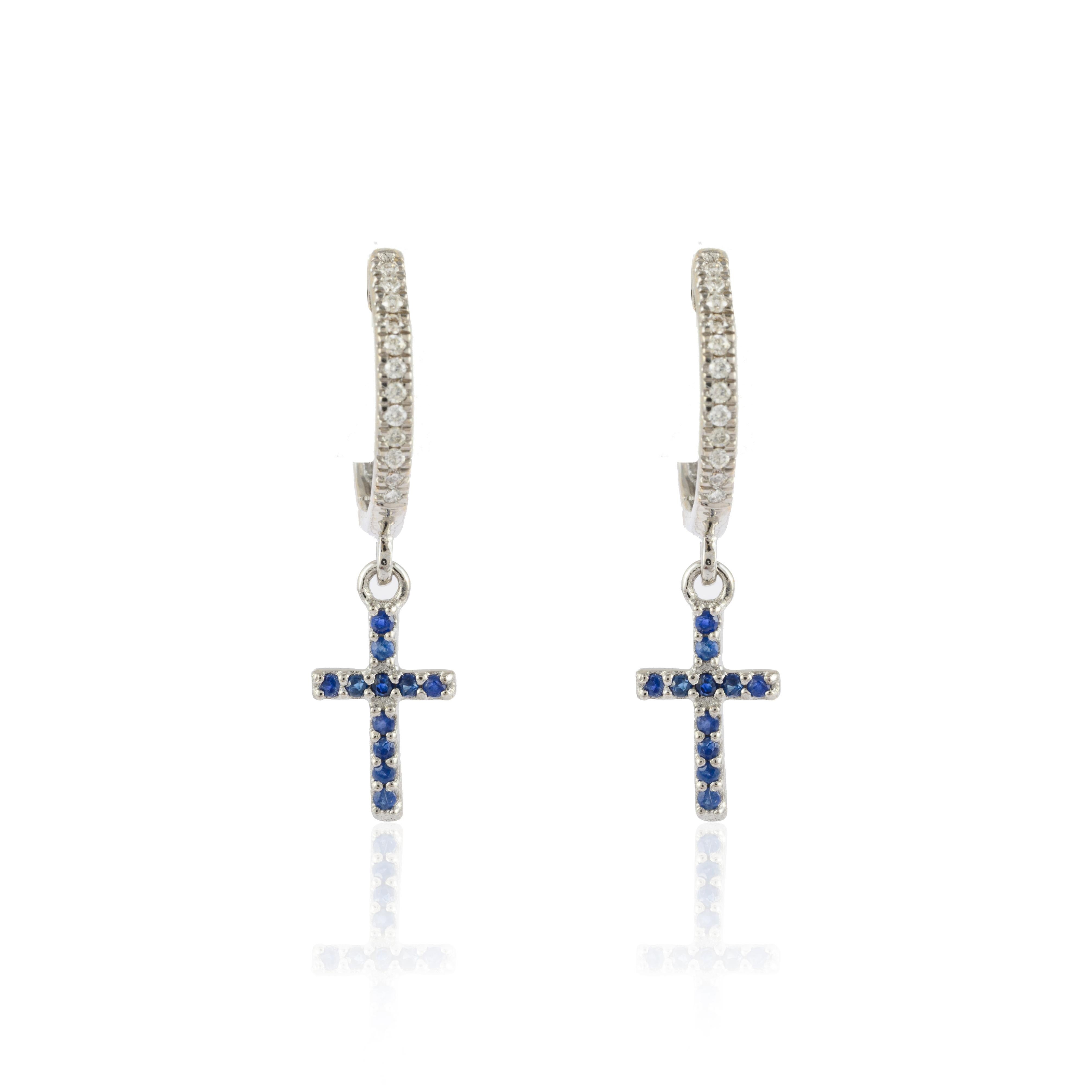 Diamond and Blue Sapphire Cross Hoop Earrings in 18K Gold to make a statement with your look. You shall need small huggie earrings to make a statement with your look. These earrings create a sparkling, luxurious look featuring round cut