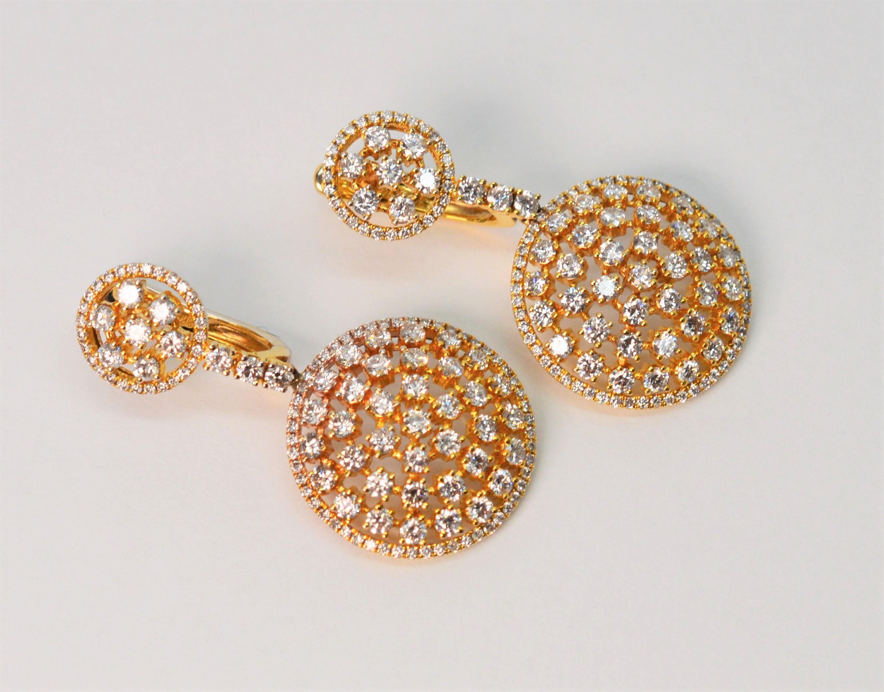 I diamanti illuminano i dischi traforati in oro giallo 18 carati di questo brillante paio di orecchini pendenti di alta moda. Adornato con brillanti bianchi che partono dal disco rotondo in oro giallo 18 carati da 10 mm e scendono fino al medaglione