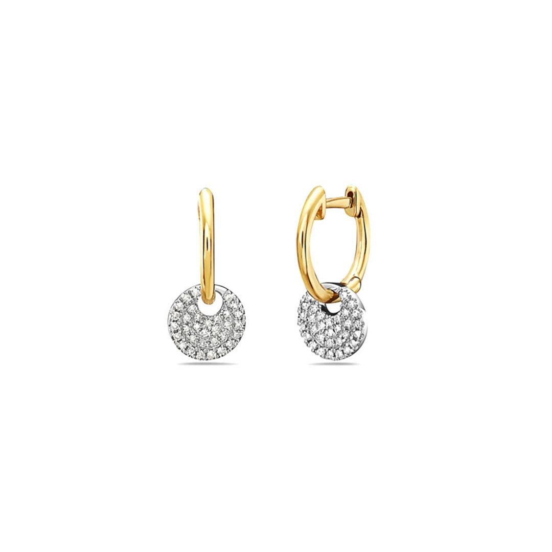 The Dangling Diamond Disc Huggies are an extraordinary blend of contemporary design and timeless elegance. These earrings feature huggie-style hoops with a modern twist – delicate, gleaming discs adorned with sparkling diamonds gracefully dangle