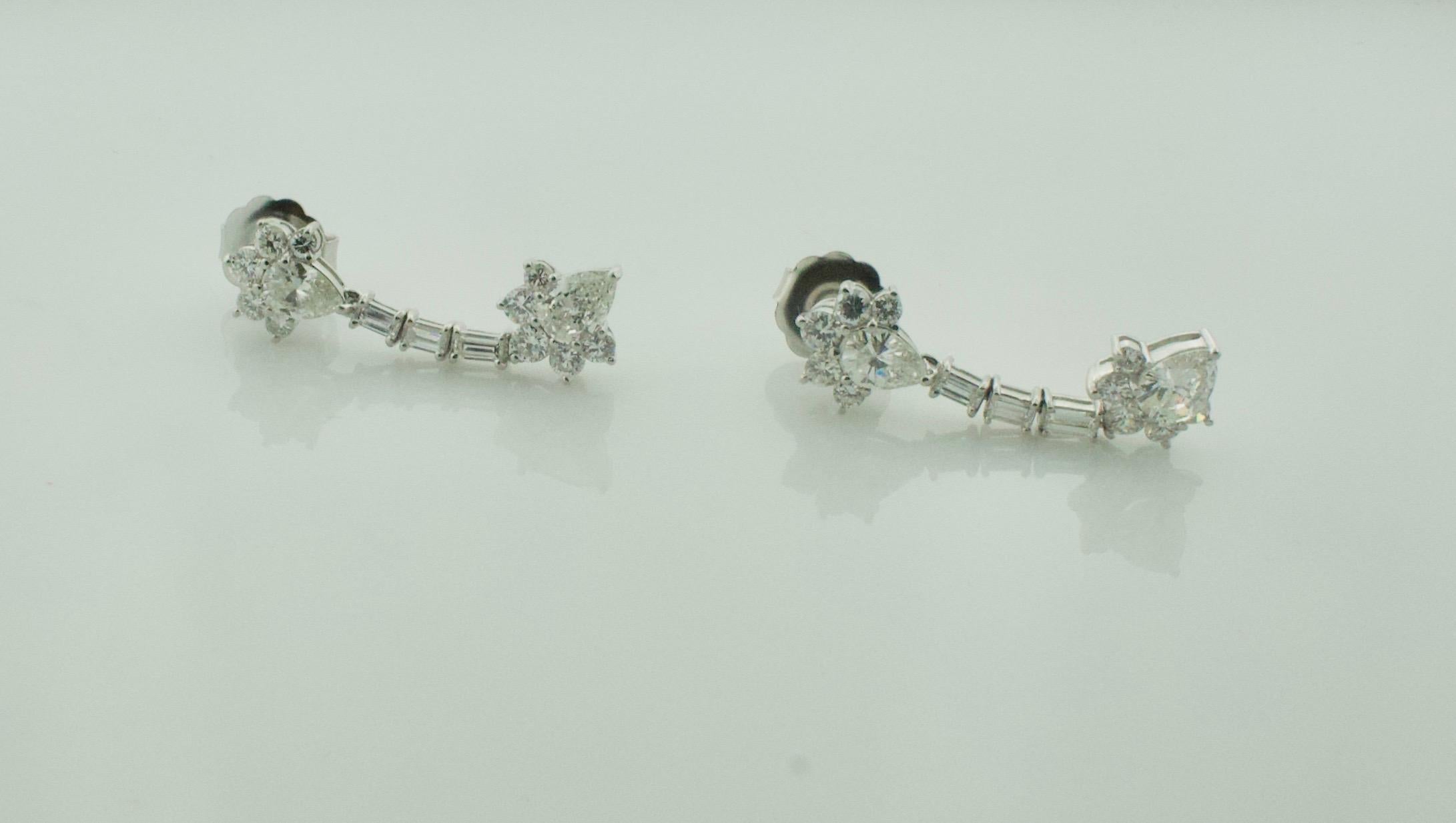 Dangling Diamond Platinum Earrings Circa 1950's 4.20 cts. Total Weight
4 Pear Shape Cut Diamonds Weighing 2.30 Carats Approximately [GHI VS2-SI1]
6 Baguette Cut Diamonds Weighing .60 Carats Approximately [GH VVS-VS1]
20 Round Brilliant Cut Diamonds