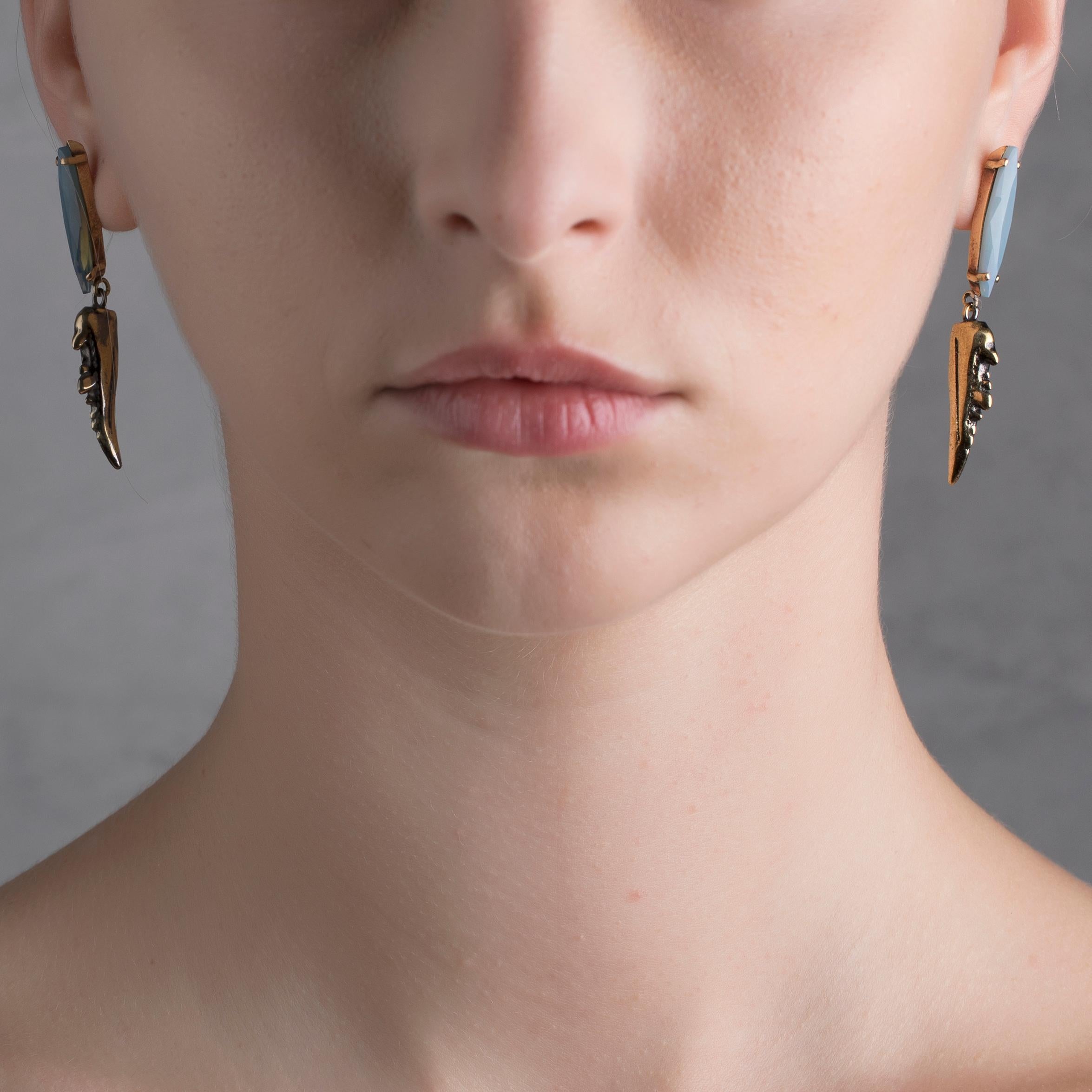 Designed in Italy, this piece belongs to the BE NOMAD jewelry collection from IOSSELLIANI, embracing the exotic dream of a different way of living. Adorned by a dangling claw, this pair of earring is crafted in hand brushed brass and features a rear