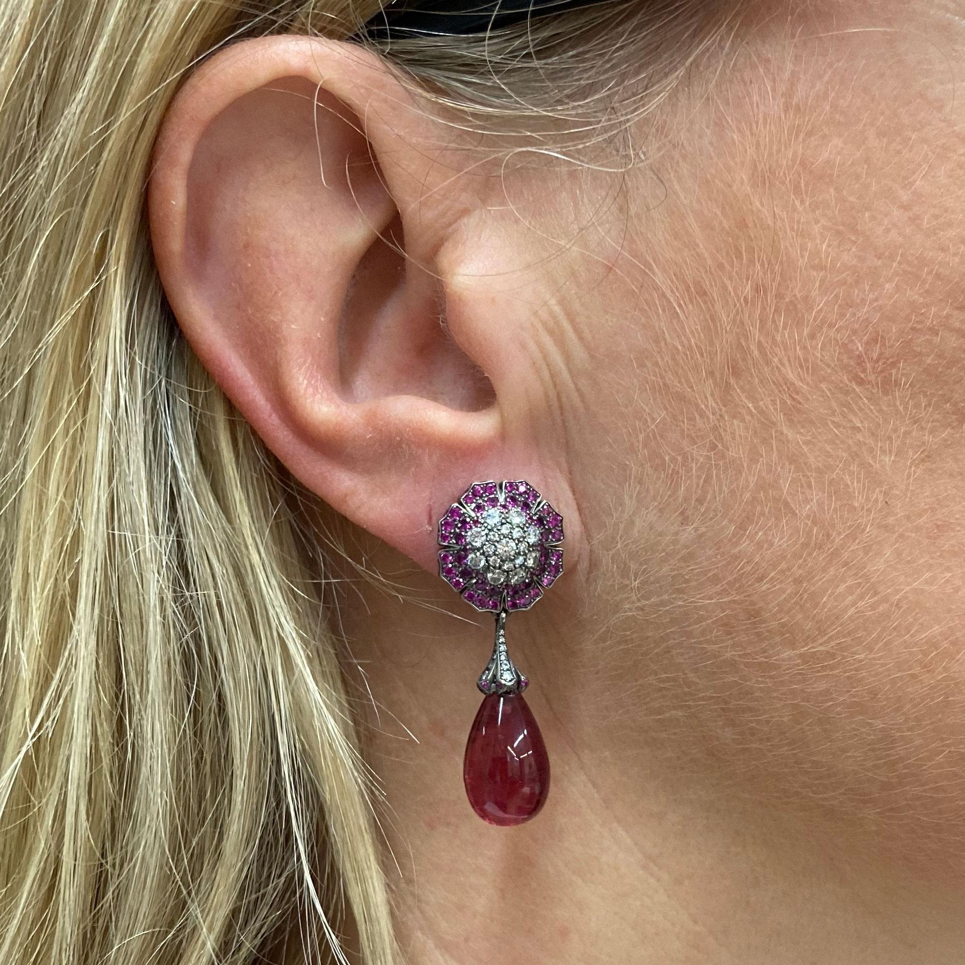 The top part of this very feminine pair of rosette shaped Earrings consists of 74 pave set Diamonds of a total weight of 0.95 ct G vvs and 158 pin Sapphires of a total weight of 1.67 ct in 18 Kt white Gold.
The dangling bottom part showcases 2