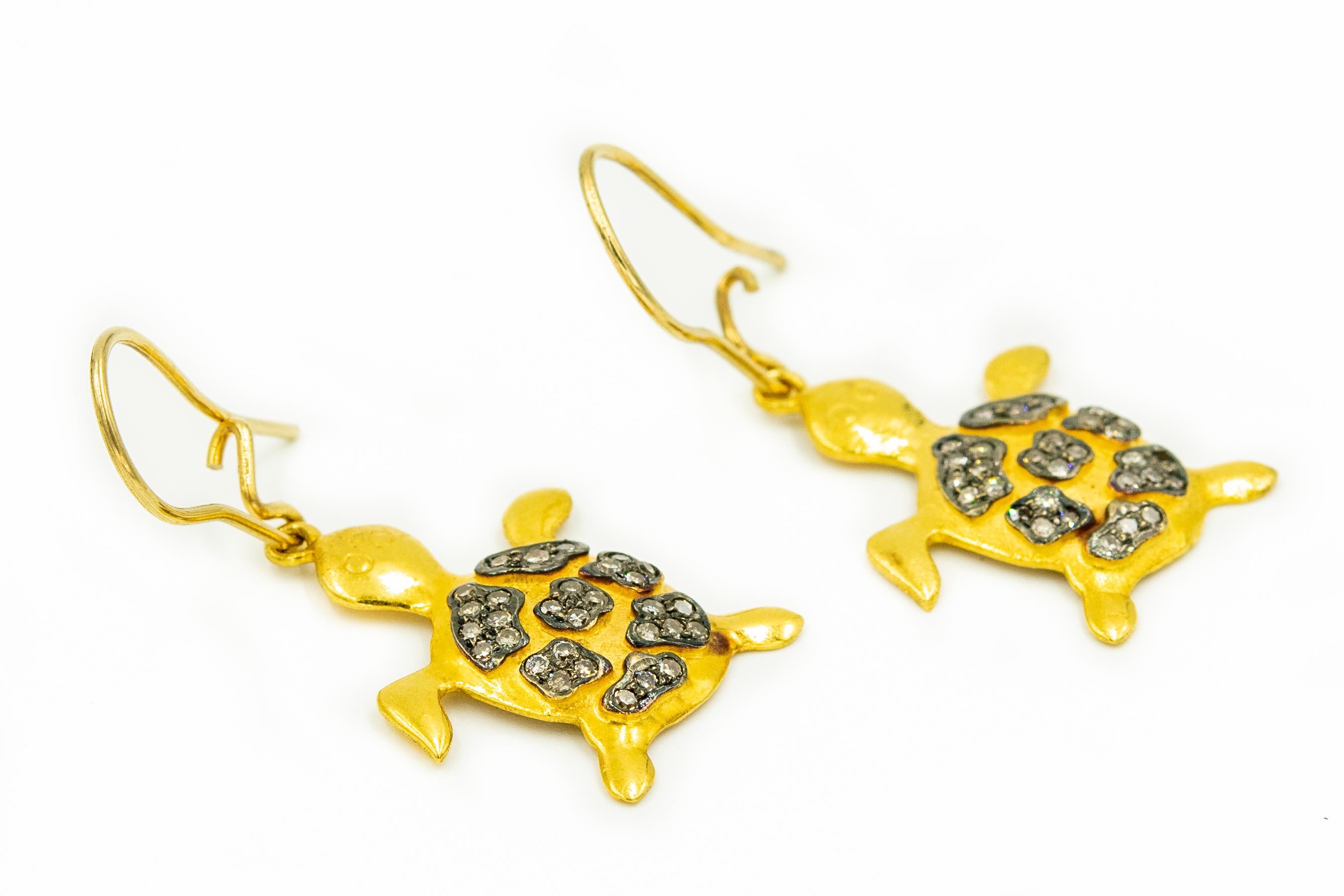 Adorable 14k turtle earrings featuring diamonds set on the back area to represent the shell pattern.  They hang on an 18k yellow gold wire.

The turtles themselves measure .86