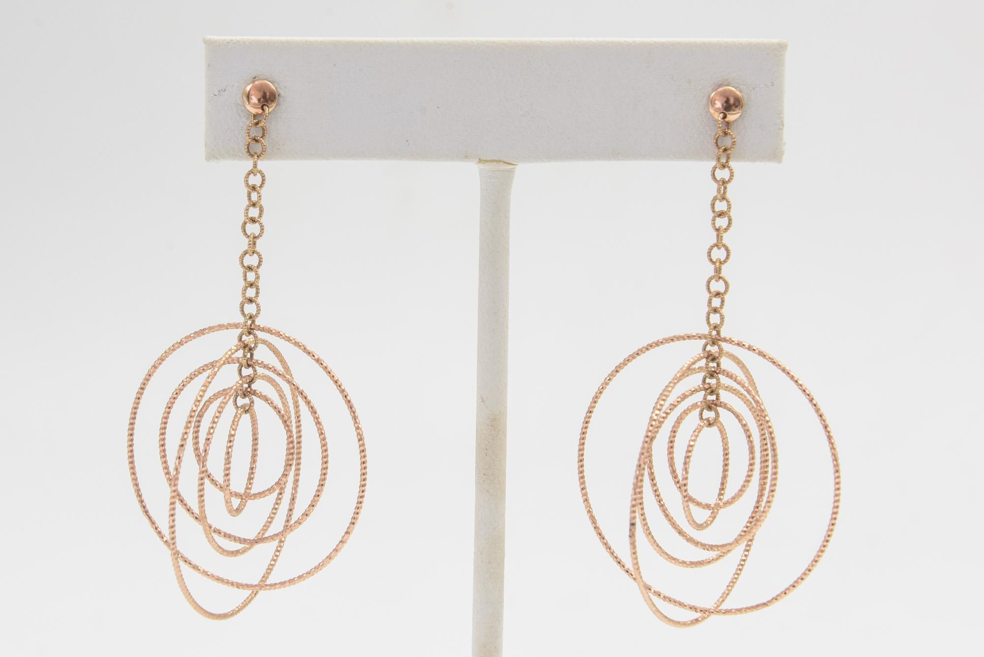 Delightful 14k rose gold dangling circle earrings featuring six  different size stylized rotating circles dropping from a stylized chain link chain and ball post.  These are post earrings so pierced ears are a must.  They are light weight so wearing