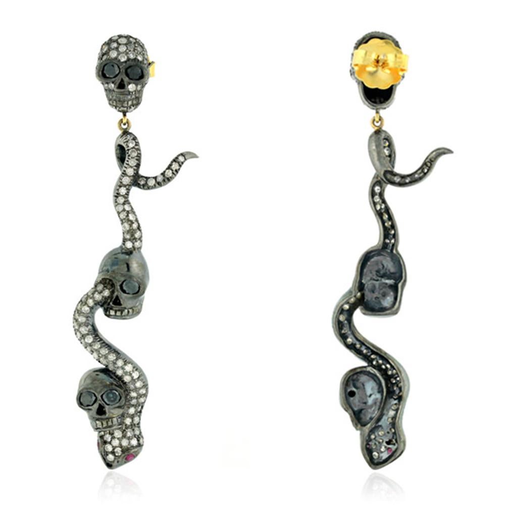 Eclectic this Dangling Snake and Skull Diamond Earring in Silver and Gold is the one you will dare to wear.
 
Closure: Push Post

18KT Gold: 1.56gms
Diamond: 4.53cts
SiIver: 18.76gms
Ruby: 0.1cts
