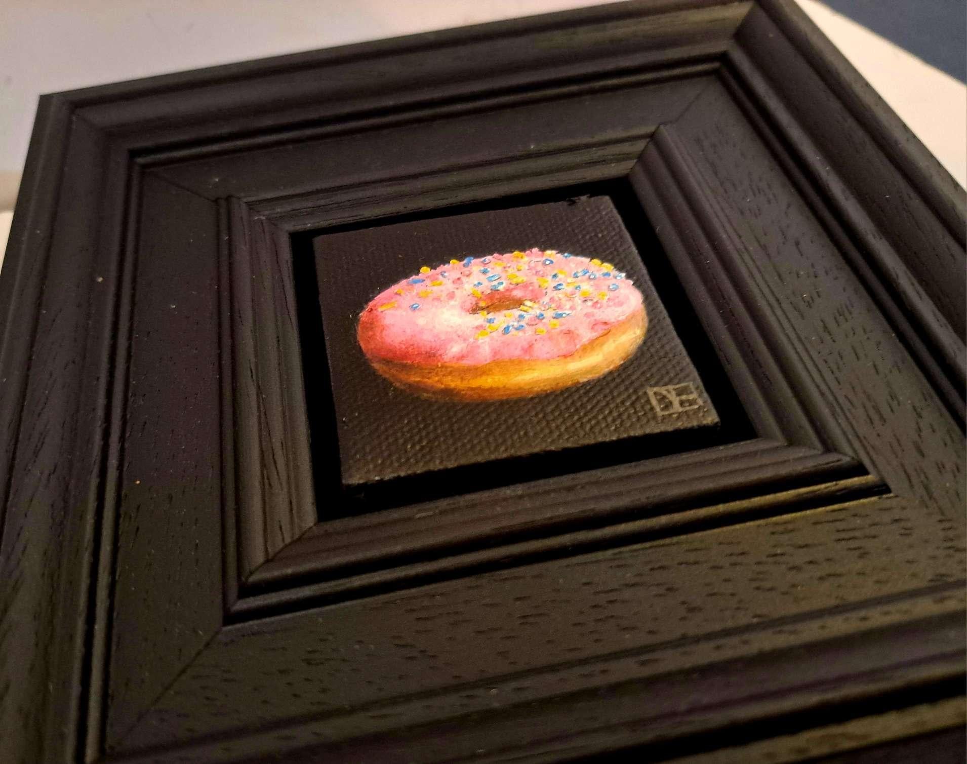 Pocket Doh-nut (with sprinkles) is an original oil painting by Dani Humberstone as part of her Pocket Painting series featuring small scale realistic oil paintings, with a nod to baroque still life painting. The paintings are set in a black wood