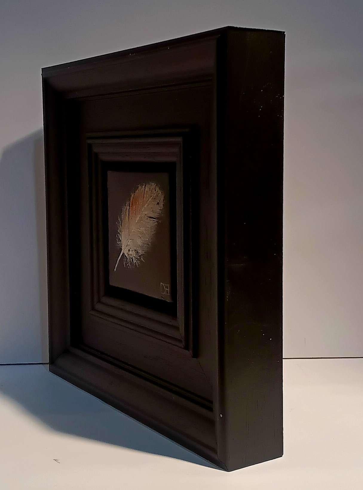 Pocket Tawny Owl feather 3 est une peinture à l'huile originale réalisée par Dani Humberstone dans le cadre de sa série Pocket Painting, qui propose des peintures à l'huile réalistes à petite échelle, avec un clin d'œil aux natures mortes baroques.