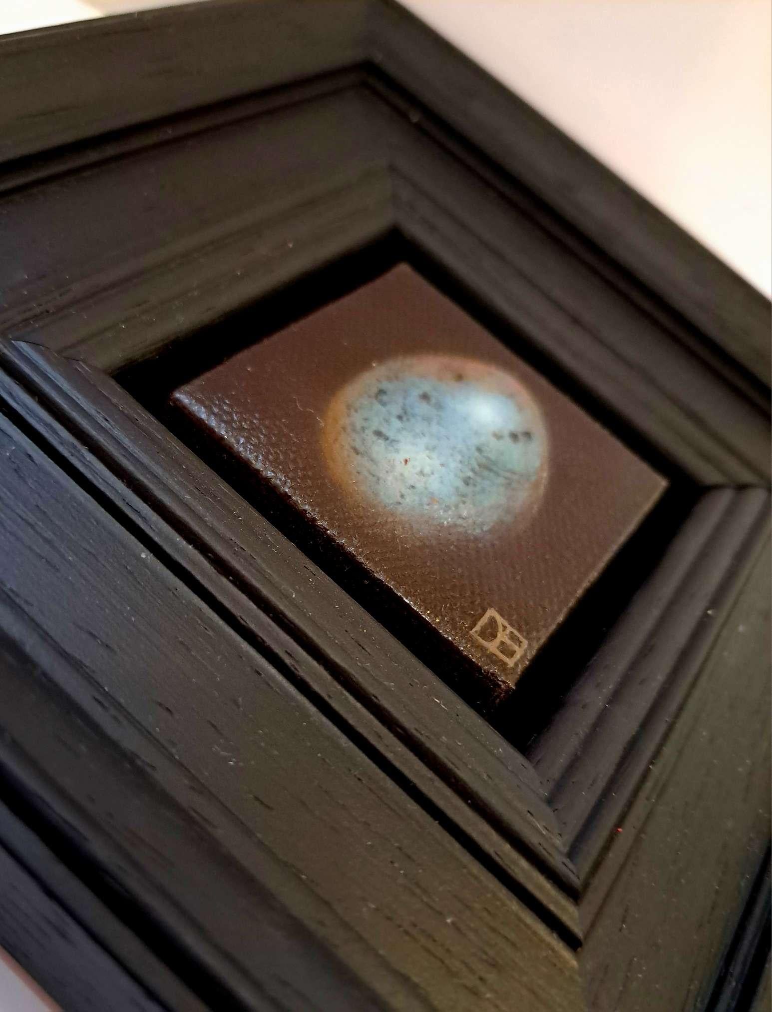 Pocket Bluer Blackbird's Egg 2 (c) è un dipinto a olio originale di Dani Humberstone che fa parte della sua serie Pocket Painting, caratterizzata da dipinti a olio realistici in scala ridotta, con un accenno alla pittura barocca di nature morte. I