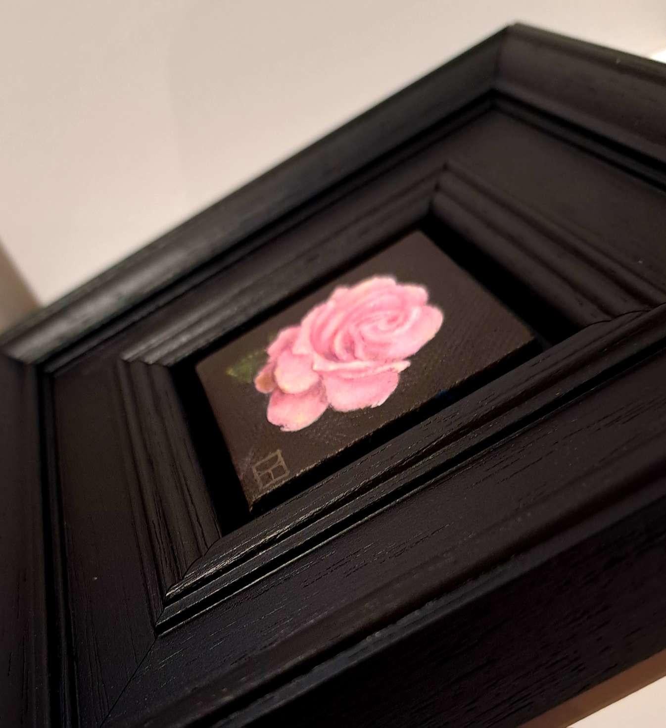 Pocket Pink Rose with Leaf ist ein Original-Ölgemälde von Dani Humberstone als Teil ihrer Pocket Painting-Serie, die realistische Ölgemälde in kleinem Maßstab mit einer Anspielung auf die barocke Stilllebenmalerei umfasst. Die Gemälde sind in einen