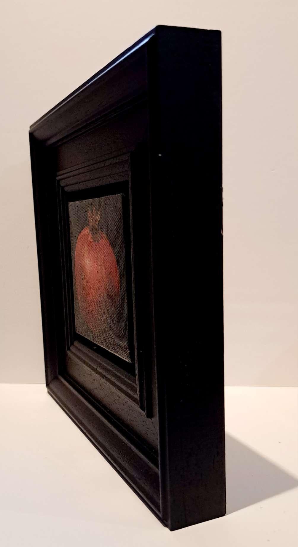 Pocket Ripe Red Pomegranate is an original oil painting by Dani Humberstone as part of her Pocket Painting series featuring small scale realistic oil paintings, with a nod to baroque still life painting. The paintings are set in a black wood layered