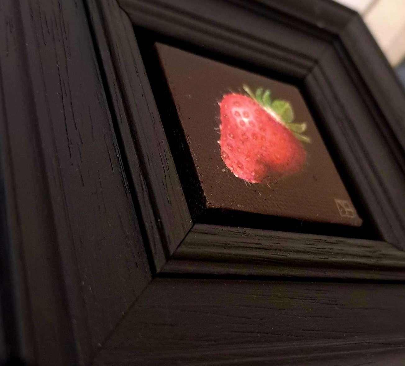 Pocket Very Ripe Strawberry ist ein Original-Ölgemälde von Dani Humberstone als Teil ihrer Pocket Painting-Serie, die realistische Ölgemälde in kleinem Maßstab mit einer Anspielung auf die barocke Stilllebenmalerei umfasst. Die Gemälde sind in einen