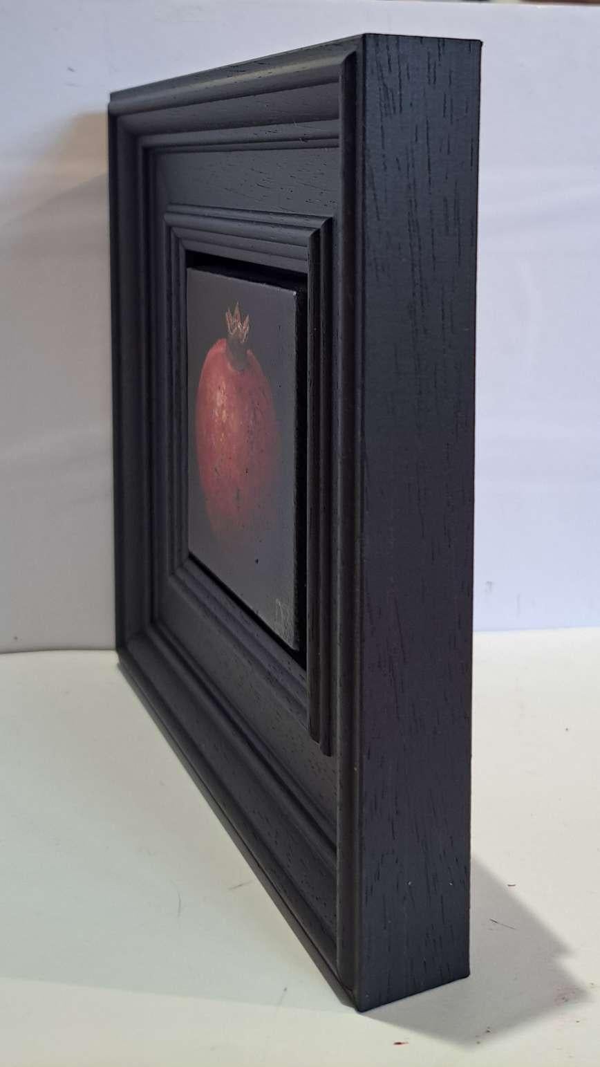 Pocket Pinky Red Pomegranate (Leinwandgröße 7x7cm) ist ein Original-Ölgemälde von Dani Humberstone als Teil ihrer Pocket Painting-Serie, die realistische Ölgemälde in kleinem Maßstab mit einer Anspielung auf die barocke Stilllebenmalerei umfasst.