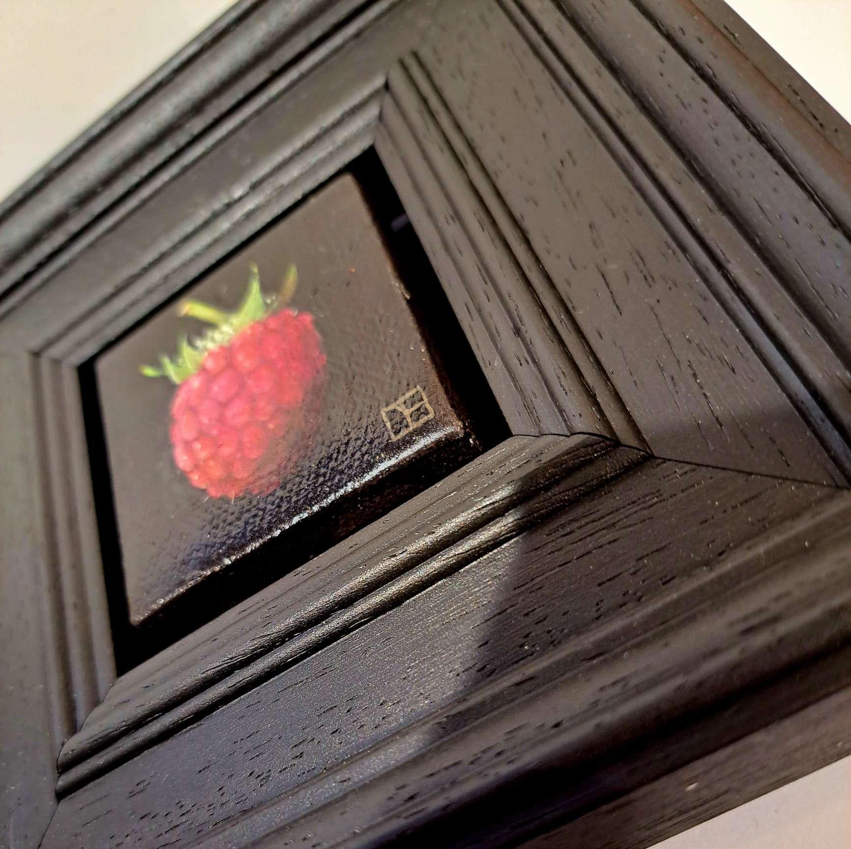 Pocket Raspberry (Pink) is an original oil painting by Dani Humberstone as part of her Pocket painting series featuring small scale realistic oil paintings, with a nod to baroque still life painting. The paintings are set in a black wood layered