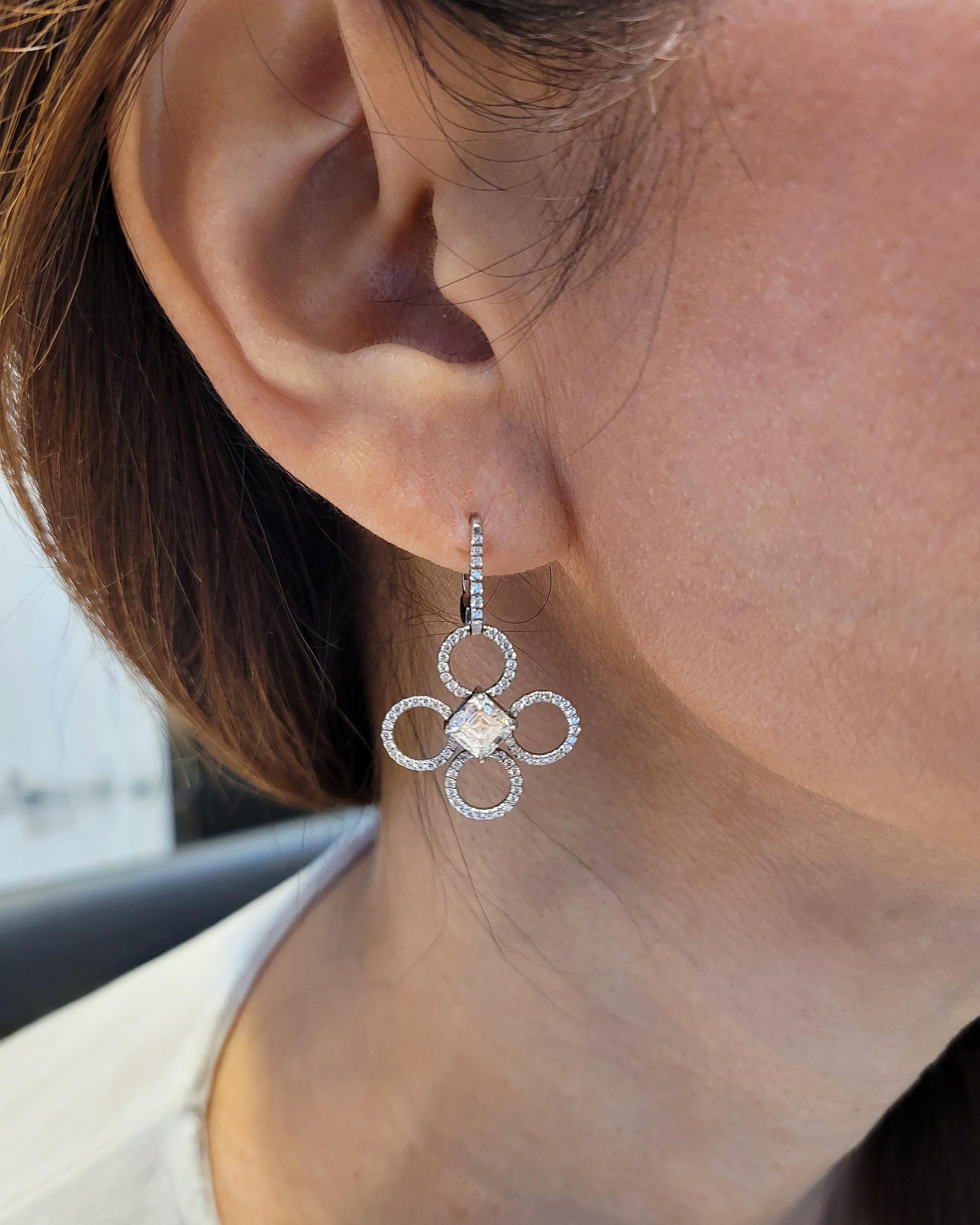 Introducing the Clover Flower Diamond Platinum Earrings by Daniel K, a stunning jewelry masterpiece that captures the essence of blooming petals. Crafted from high-quality platinum, these earrings feature two Asscher-cut diamonds in the center