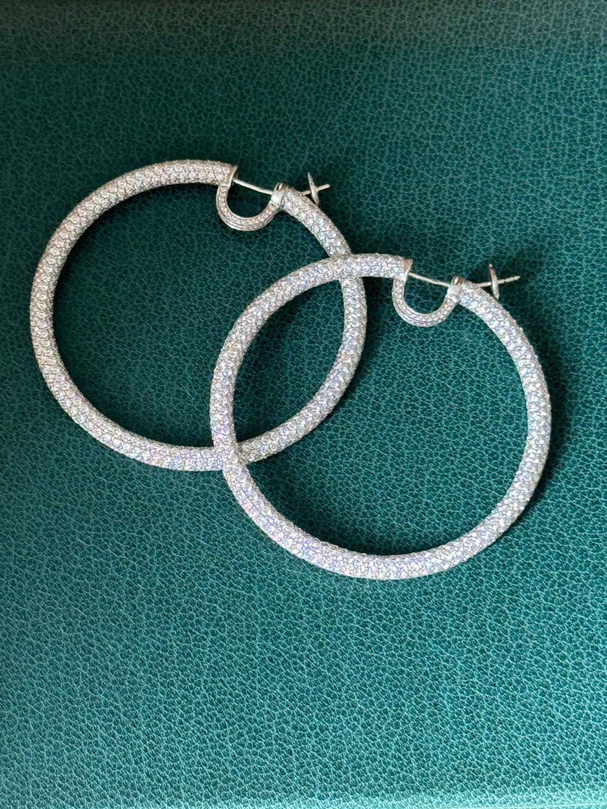 A beautiful and elegant pair of hoops earring signed Daniel K in white gold 18K. These earrings are full of round diamonds inside out and have small diamond hoops around the earlobe. 

The weight of each earring is 11,20g for one and the other one