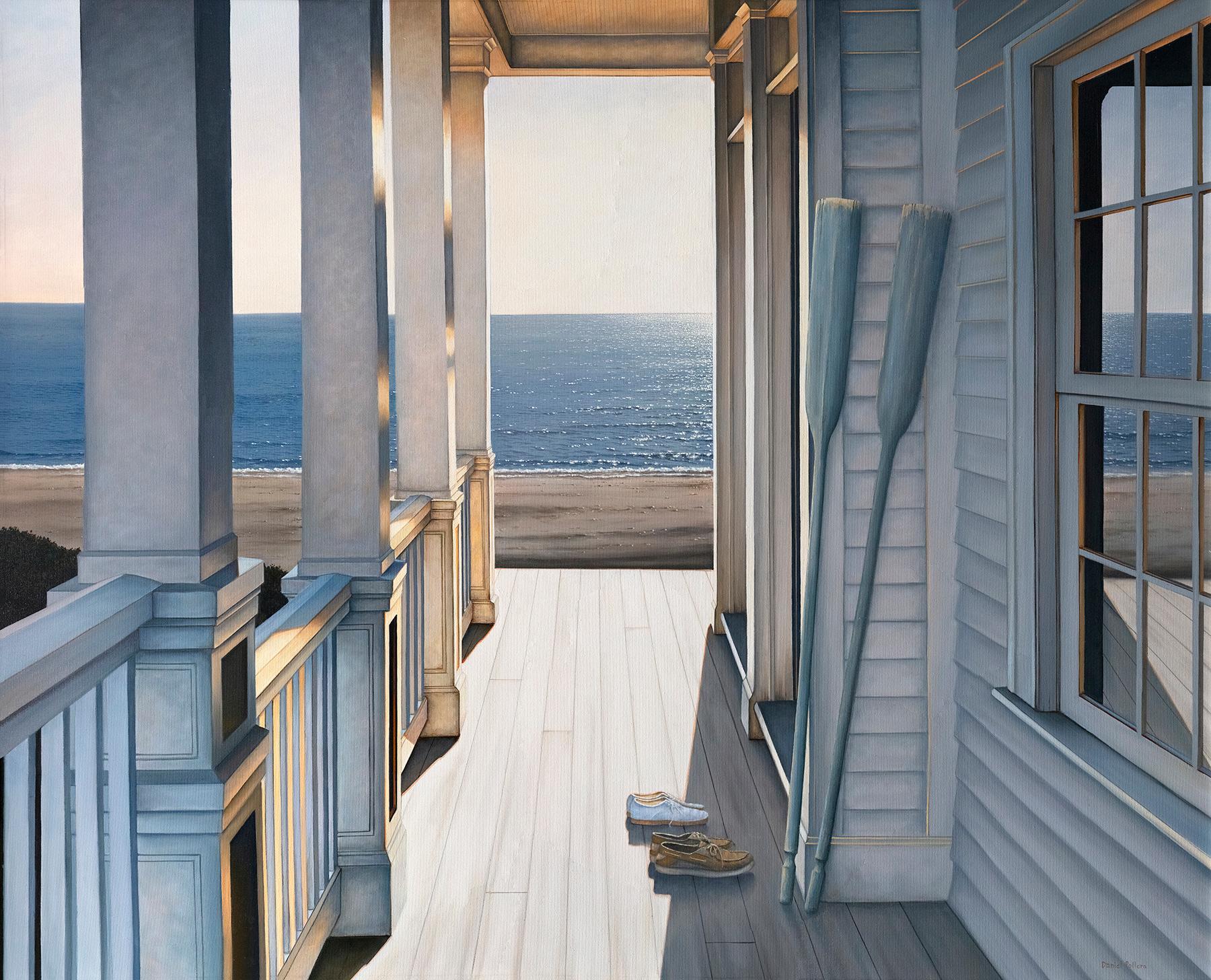 This coastal seascape limited edition print captures a scene from the porch of a beachfront property along the coast. A setting sun casts sharp light and cool blue-grey shadows across the porch, where two sets of shoes and two boat paddles rest