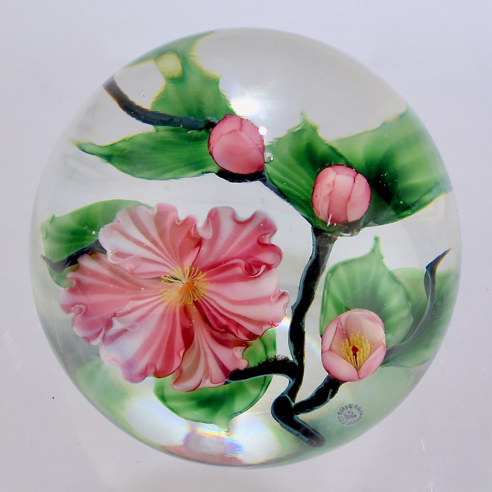 A fine Lundberg Studios paperweight by Daniel Salazar.

With a lampwork cherry blossom and 3 small cherry flower buds on a branch.

Bearing a Lundberg Studios signature cane below the flowers and an etched signature to the foot. 

Simply a