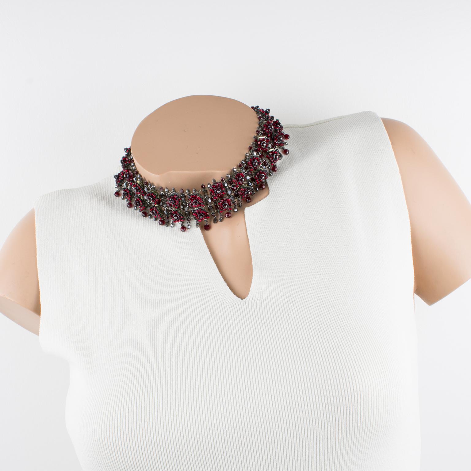 This stunning Daniel Swarovski Paris couture jeweled choker necklace features an around-the-neck shape with Victorian-inspired flair.  The choker is built with silvered metal chains background ornate with ruby red and smoked gray Swarovski crystal
