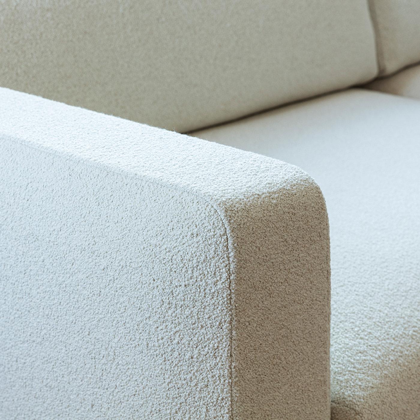 This clean-lined sofa will make for an impeccable addition to a contemporary private study or light-toned lounge area thanks to its ethereal, almost aseptic flair. Entirely covered in a textured white fabric for a superb tactile feel, it features a