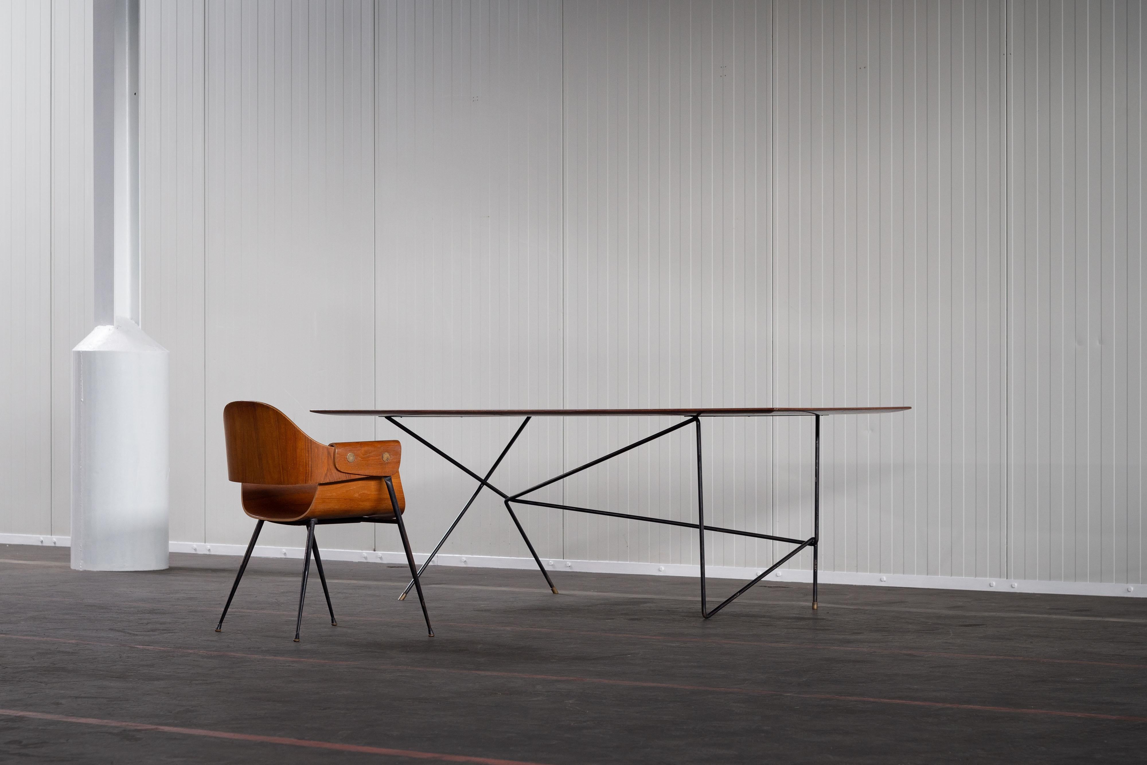 Esta fantástica mesa de escritorio fue fabricada personalmente por Daniele Calabi para su propio uso en 1950. Es una pieza única con un llamativo armazón asimétrico de alambre con patas de latón y una tapa ovalada-rectangular de nogal. El marco da