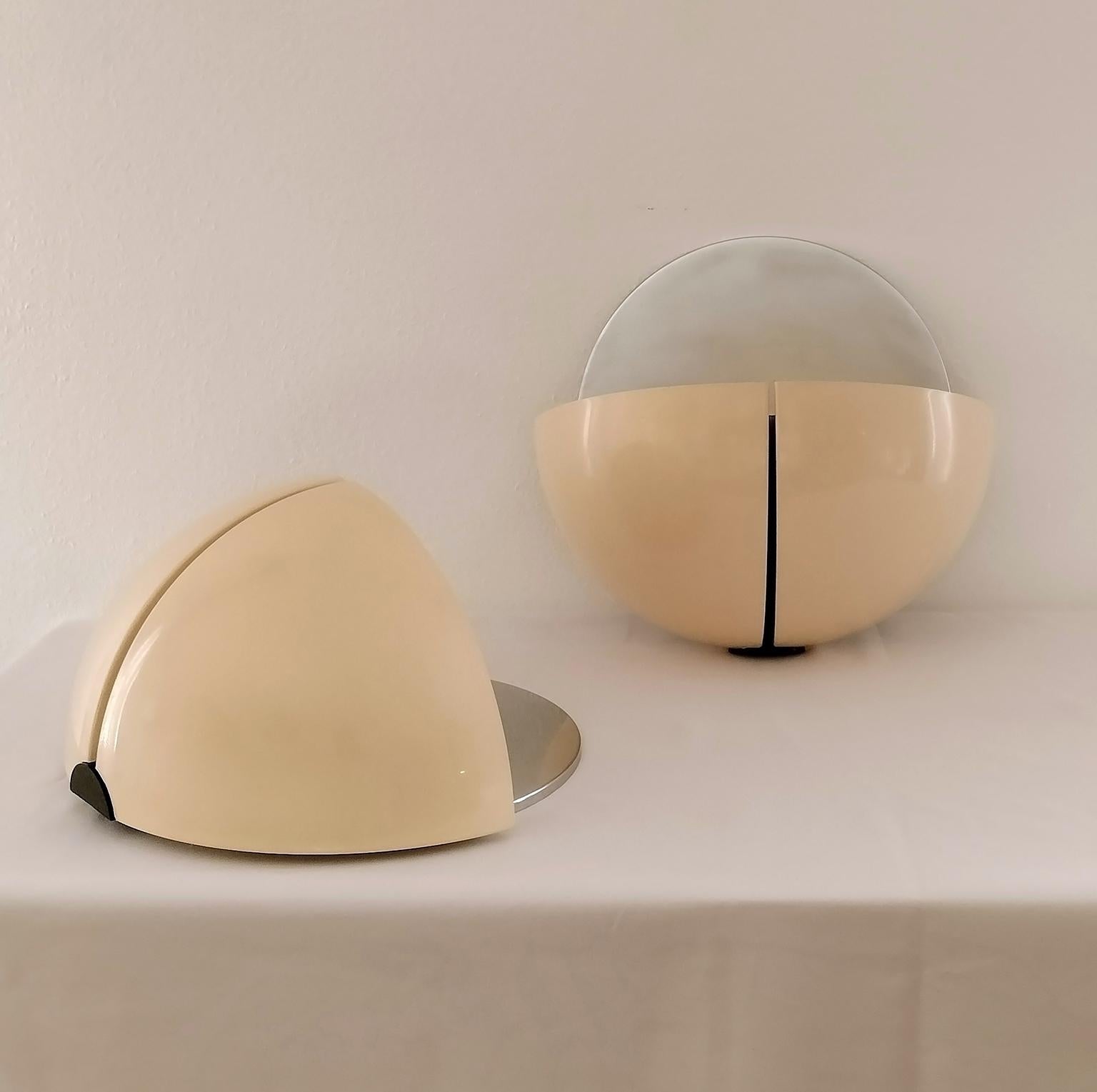 Set of two Spicchio sconces or wall lamps, designed by the Aroldi brothers and manufactured by Stilnovo in the 1970s. 

The Spicchio lamps were designed in various models including floor lamps, table lamps, and also a wall lamp version without the