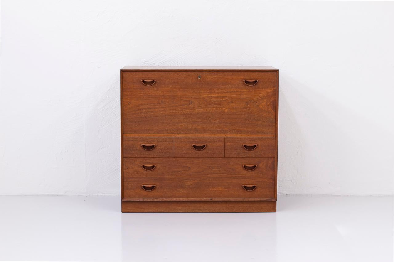 Danish Modern teak secretary cabinet by Peter Hvidt and Orla Mølgaard-Nielsen.
Manufactured by Søborg Møbelfabrik in Denmark, circa 1950s. Made from
solid teak with drop-down surface featuring finger-joint details, carved handles and dovetailed