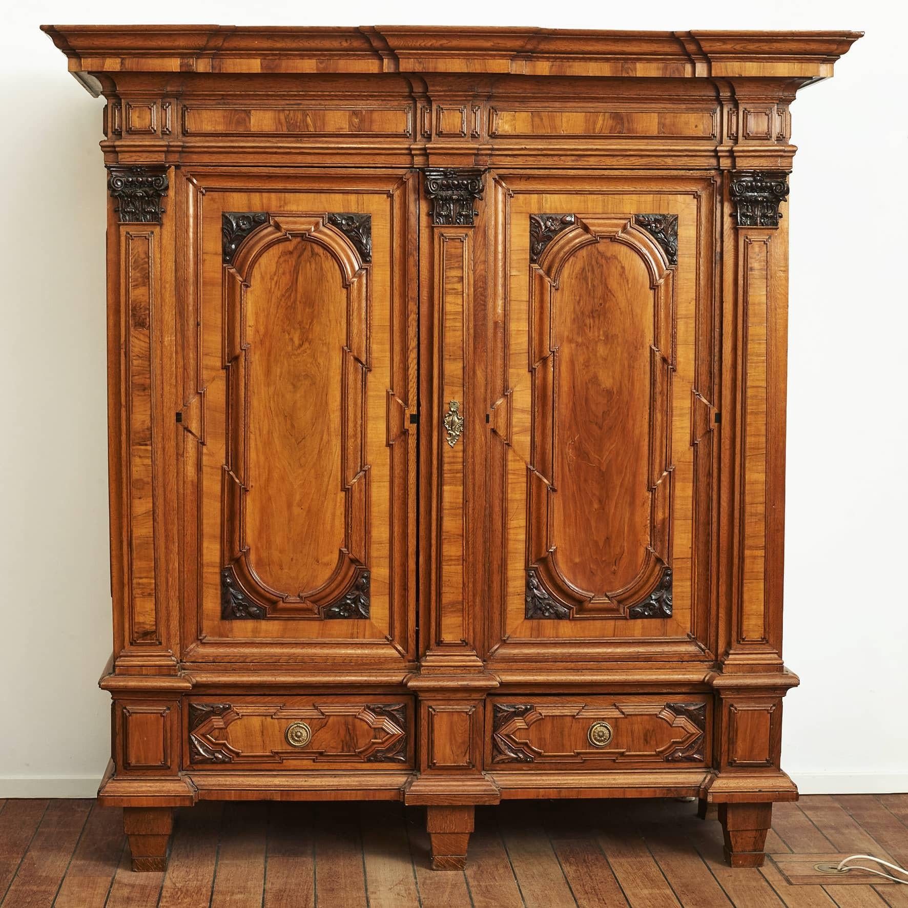 Impressive two-door baroque cabinet or armoire in oak and walnut.
From a Danish manor house, c. 1730-1750.
This large-sized cabinet features an architecturally architecture including a top section with a nicely molded and overhung breakfront