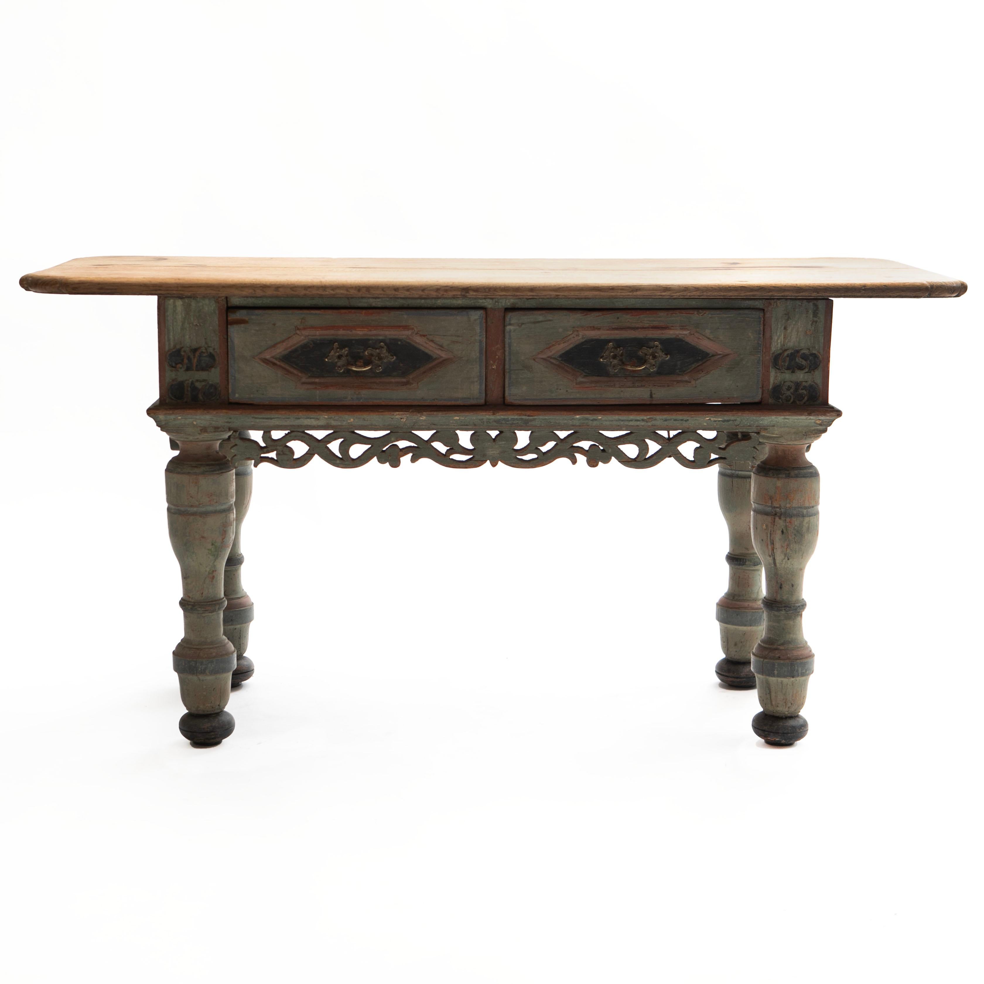 An extremely decorative 18th century Danish Baroque oak wood table.
The original light oak table top complements a frame in soft, original colors, showcasing a stunning authentic patina and natural distress.

The apron features two drawers and a