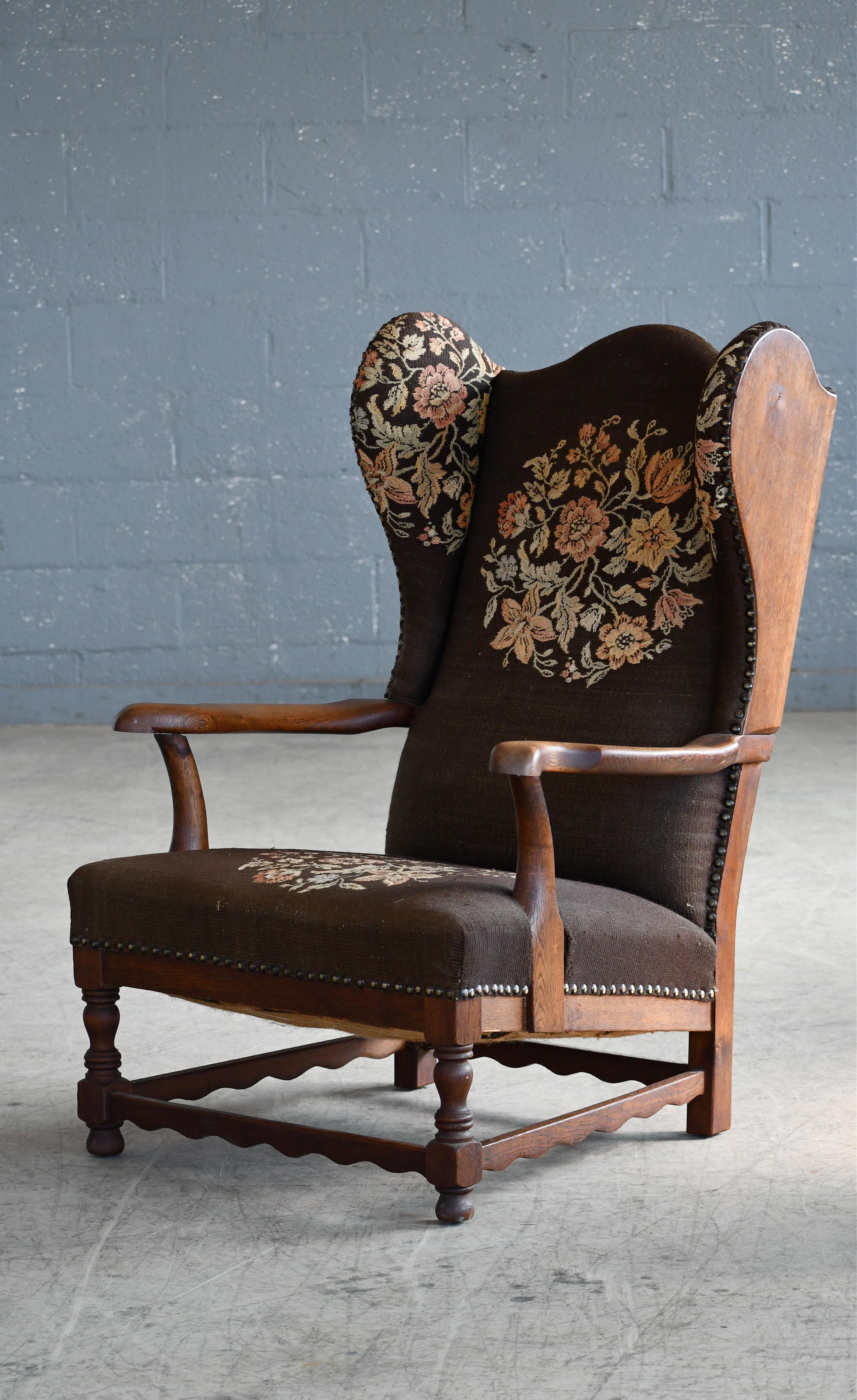 Großartiges Beispiel für frühes dänisches Midcentury Design, ca. 1930er Jahre Ohrensessel in handgeschnitzter massiver Eiche mit freiliegenden Seiten und Messingnägeln. Robuste und starke Konstruktion mit großzügigen Proportionen für einen sehr