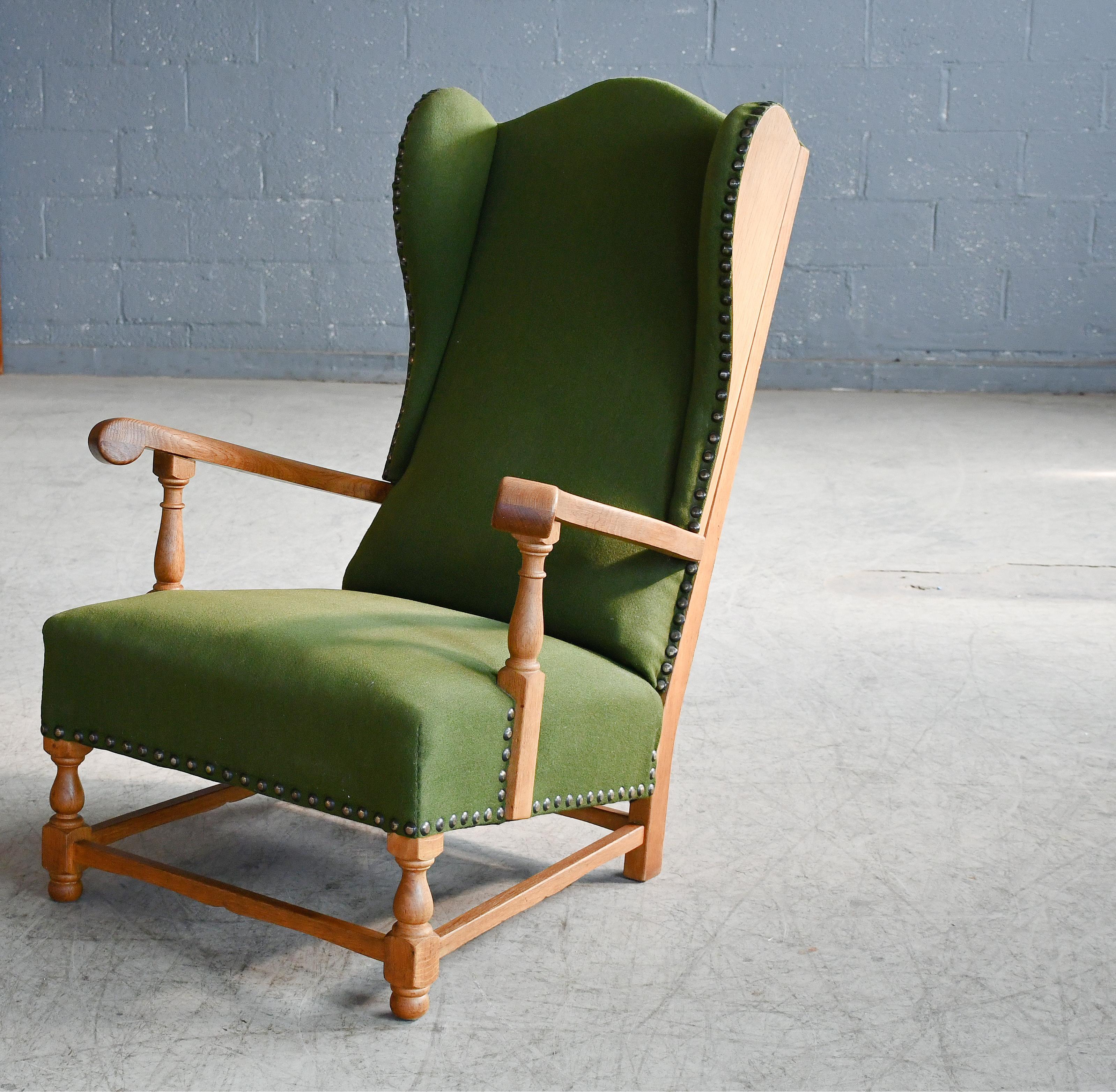 Great example of early Danish midcentury design, circa 1930s wingback chair in hand carved solid oak with exposed sides and brass nails. Sturdy and strong construction of generous proportions making for a very comfortable chair. Nice patina