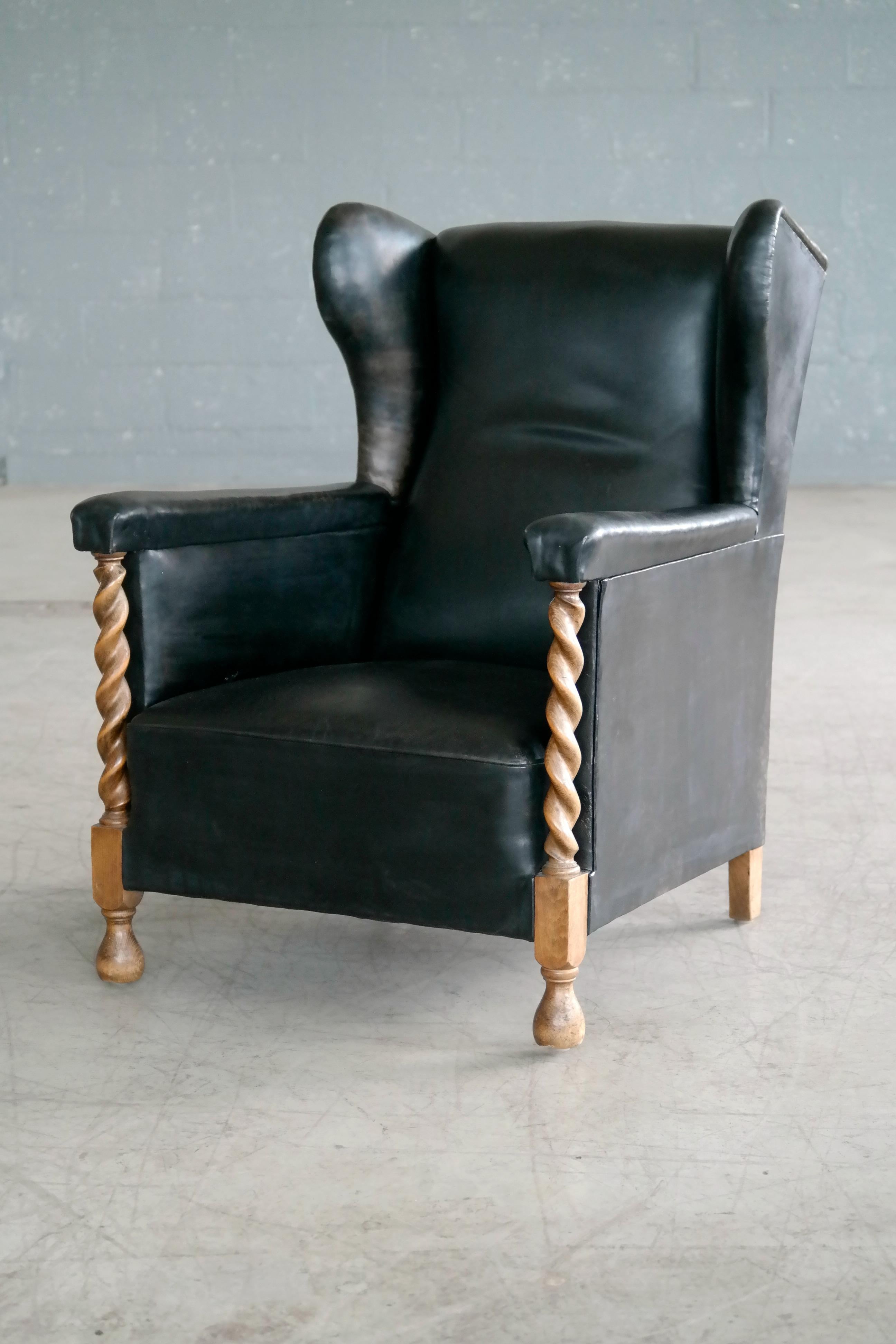 Hand-Carved Danish 1930s Large Scale Club or Wingback Chair in Black Leather and Carved Oak