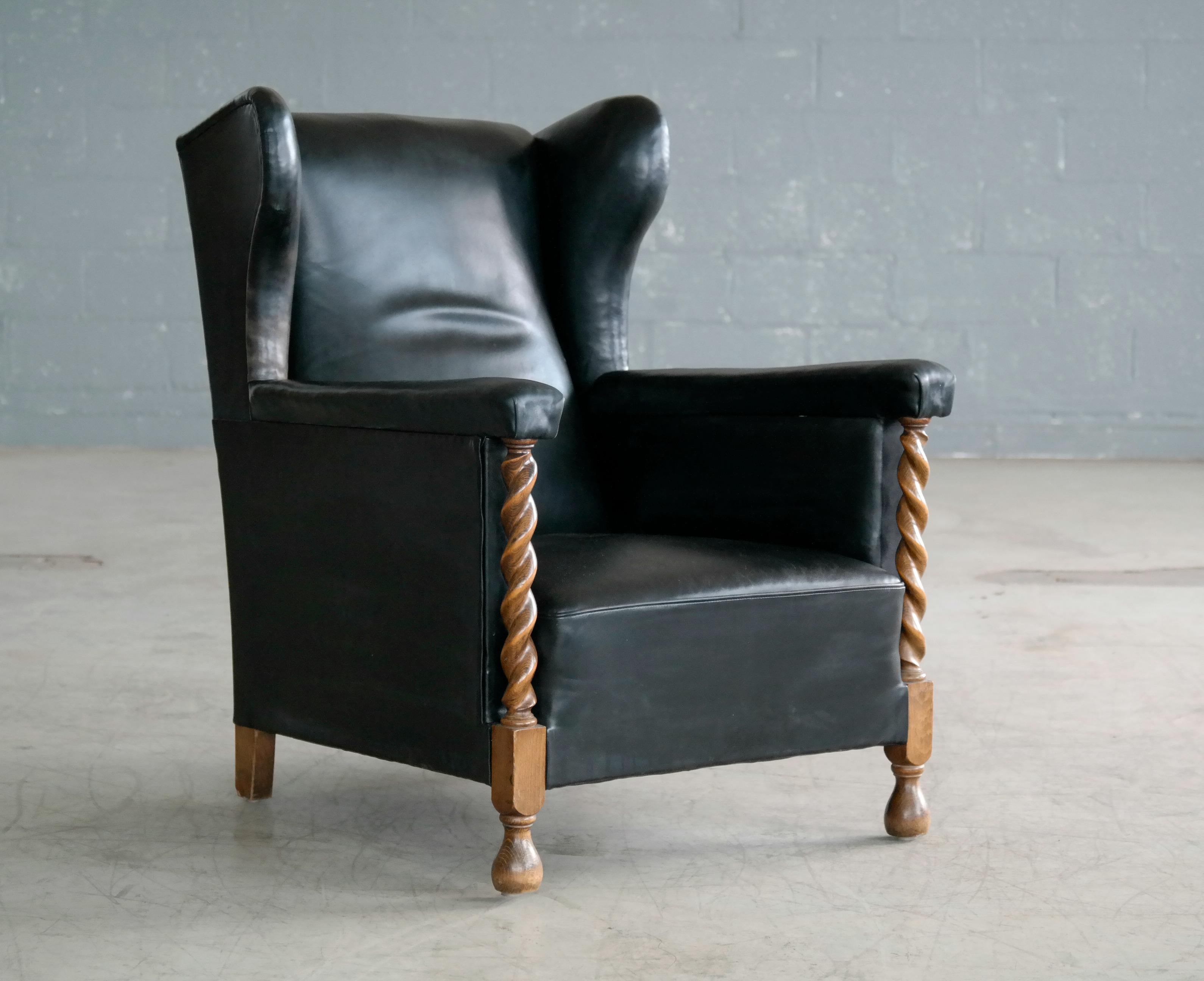 Mid-20th Century Danish 1930s Large Scale Club or Wingback Chair in Black Leather and Carved Oak