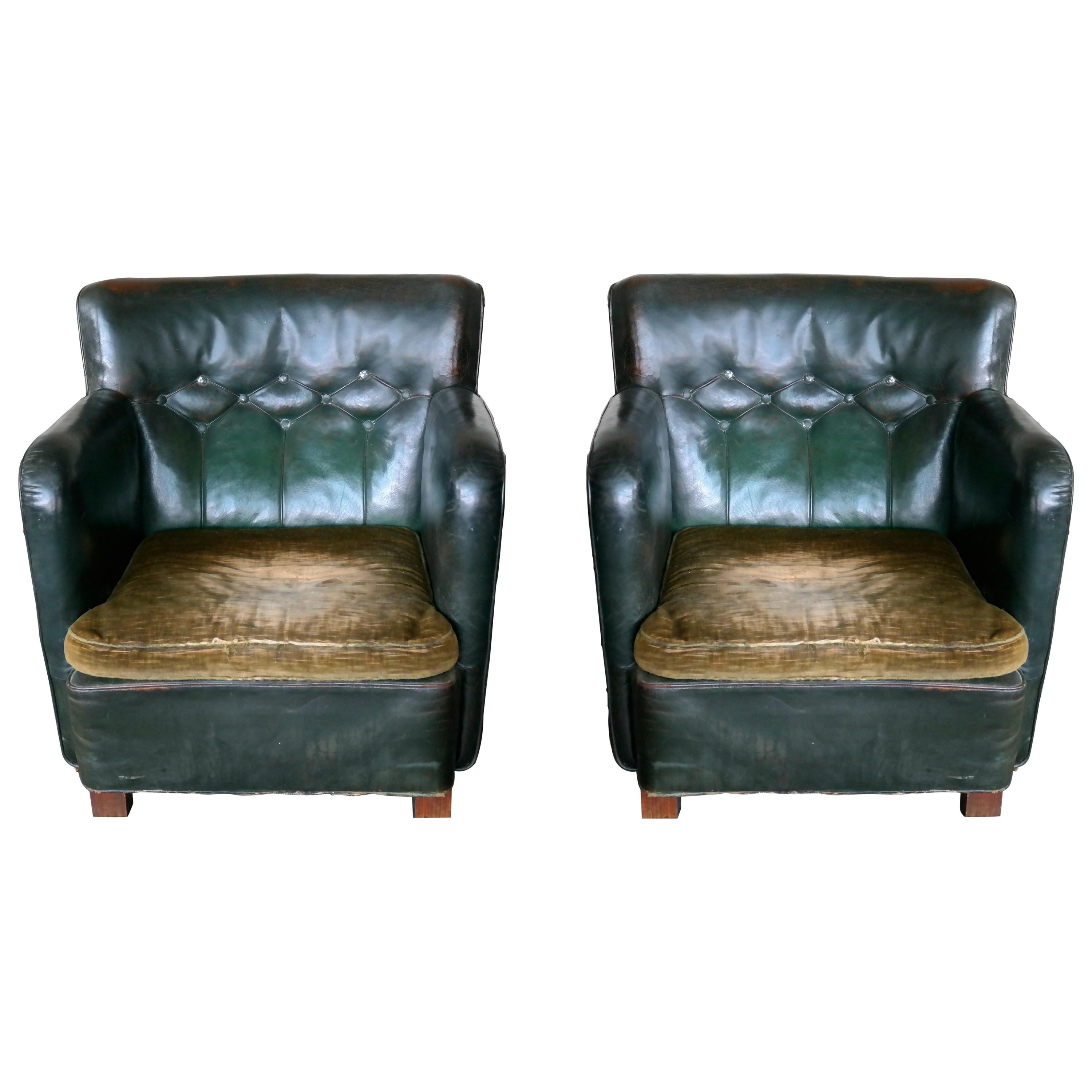 Fantastic pair of Danish club armchairs made by unknown manufacturer around the mid 1930's. Tufted backs with metal buttons in original amazing racing green colored leather with brass tacks on the sides. Original patina and with areas of the backs,