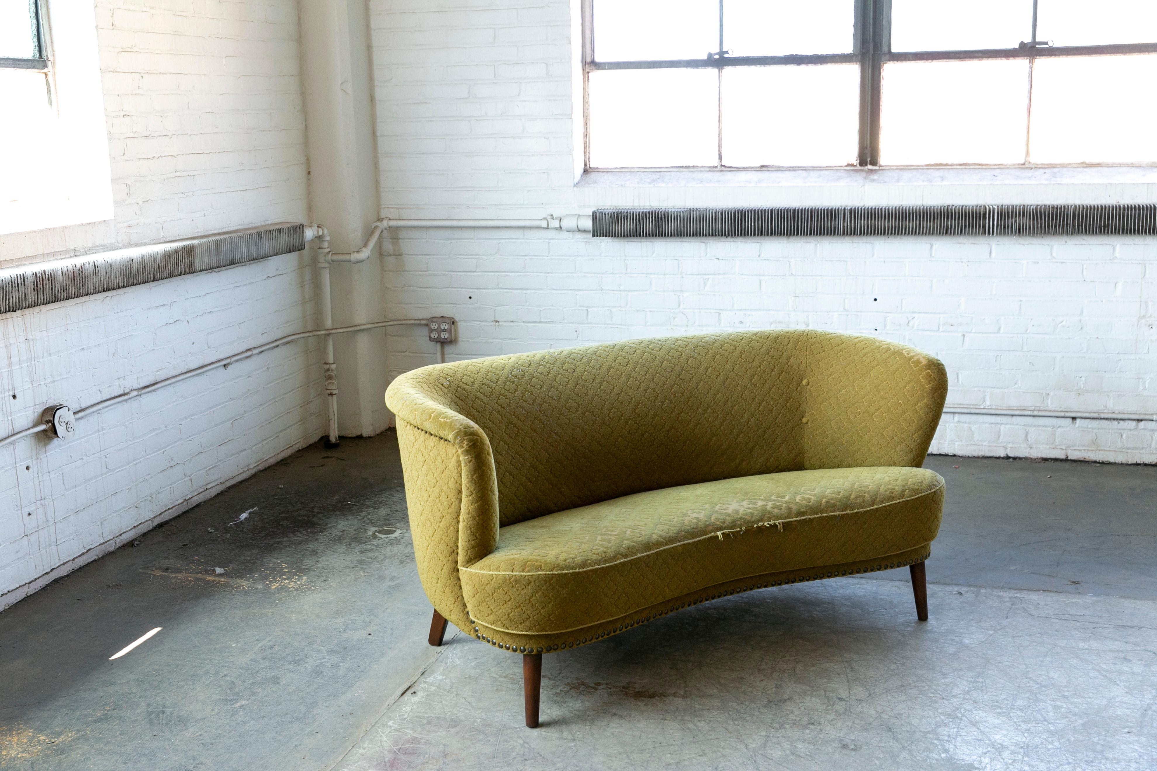 Beautiful and very elegant 1940s curved two-seat sofa from the 1940's. Often called banana sofas by the Danes due to the curved shape This sofa has slightly more straight backrest and the taller legs indicate a production date closer to 1950 when