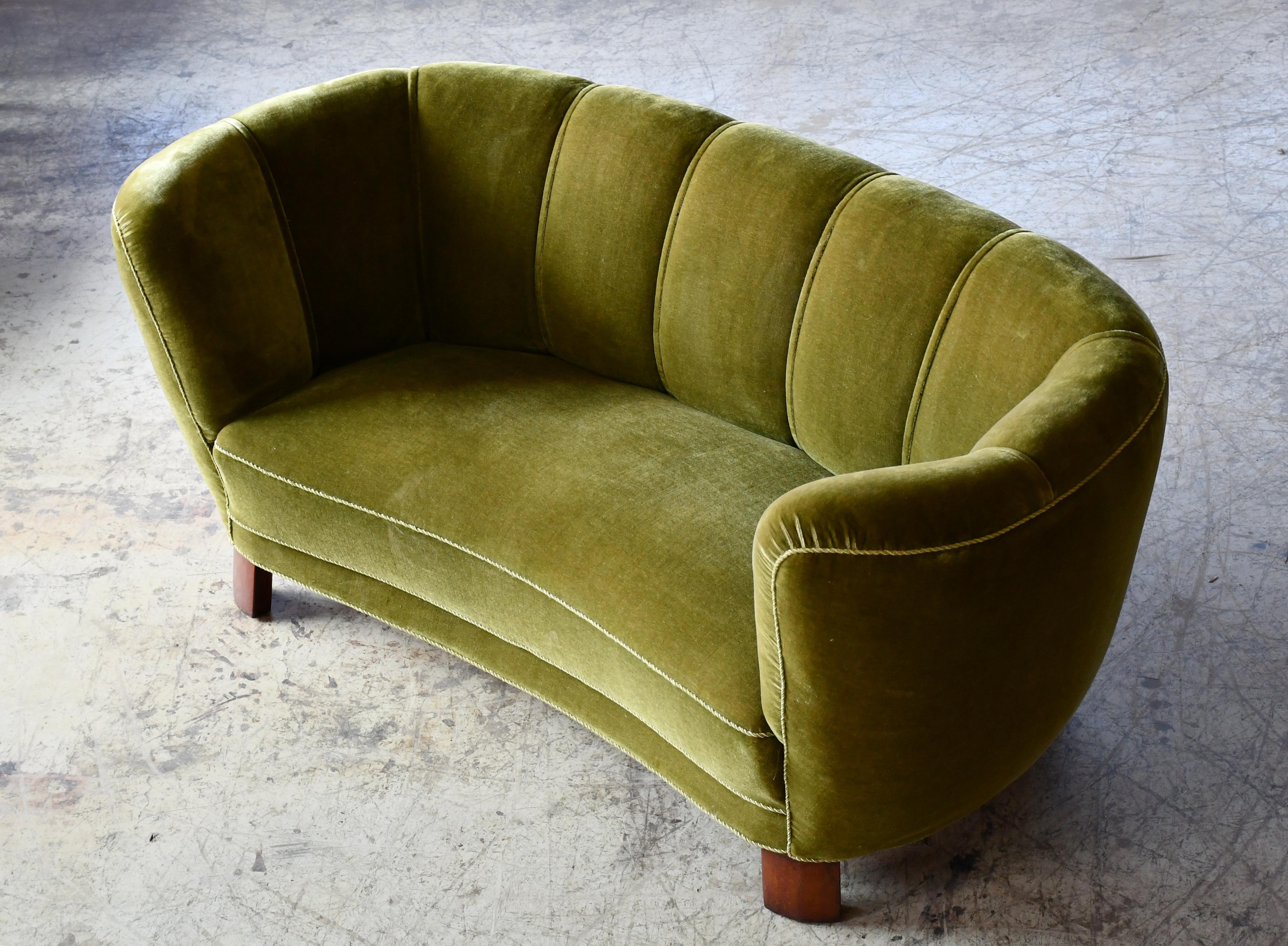 Beautiful and very elegant Danish 1940s curved loveseat  raised on a beech frame and legs. These type of sofas was manufactured from the 30's and up through the early 50's.  Solid construction with springs in the seat and the backrest for support