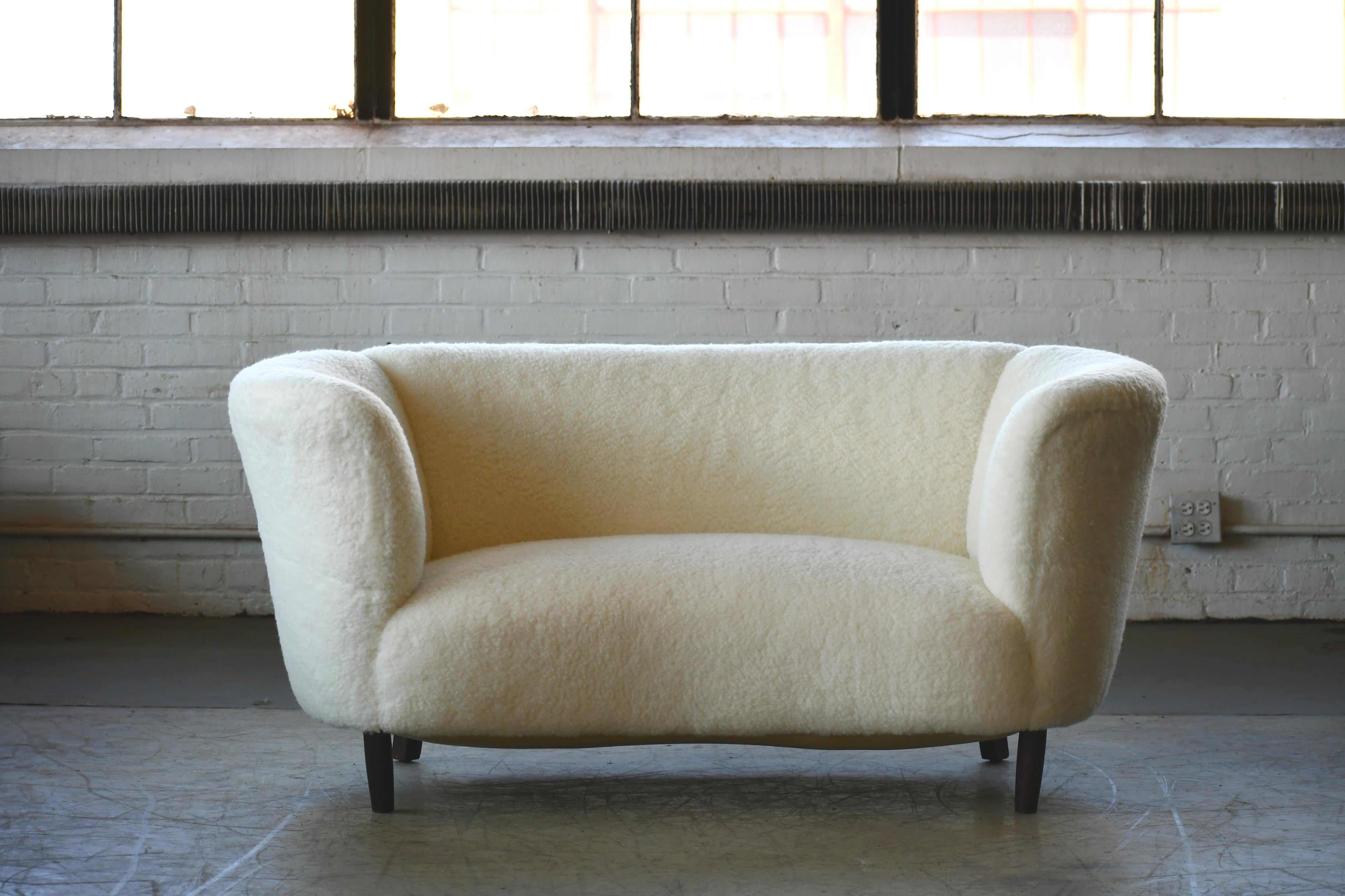 Banana shaped Viggo Boesen style curved two-seat sofa or loveseat, made in Denmark in the 1940s. This exuberant loveseat or sofa will make a strong statement in any room. Beautiful round organic lines that fully envelopes you in comfort. Fully