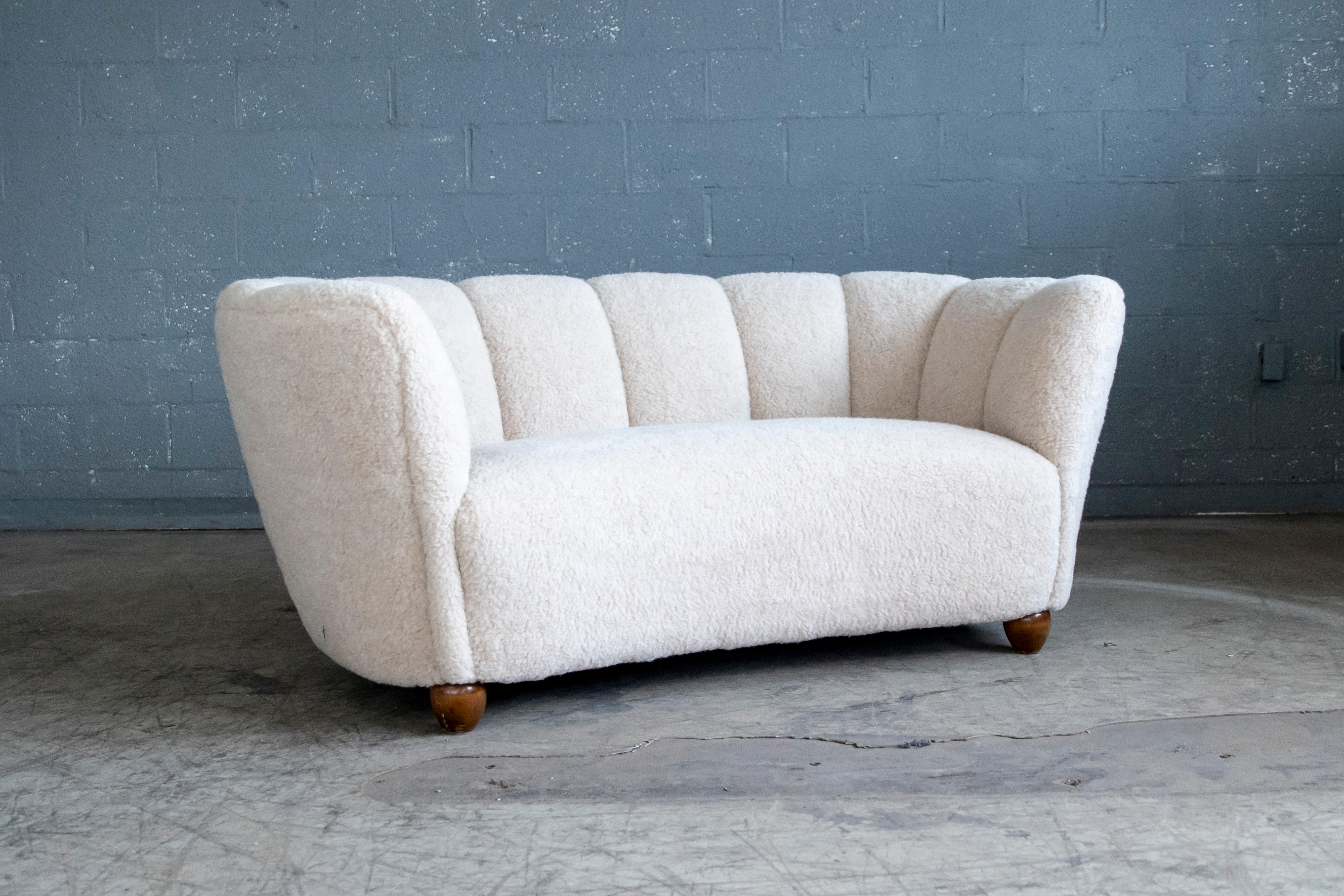 Banana shaped curved two-seat sofa or loveseat made in Denmark in the 1940s. Great statement piece. Super comfortable. Beautiful round organic lines and iconic ball feet. Fully refurbished and newly upholstered with beige Australian 100% merino