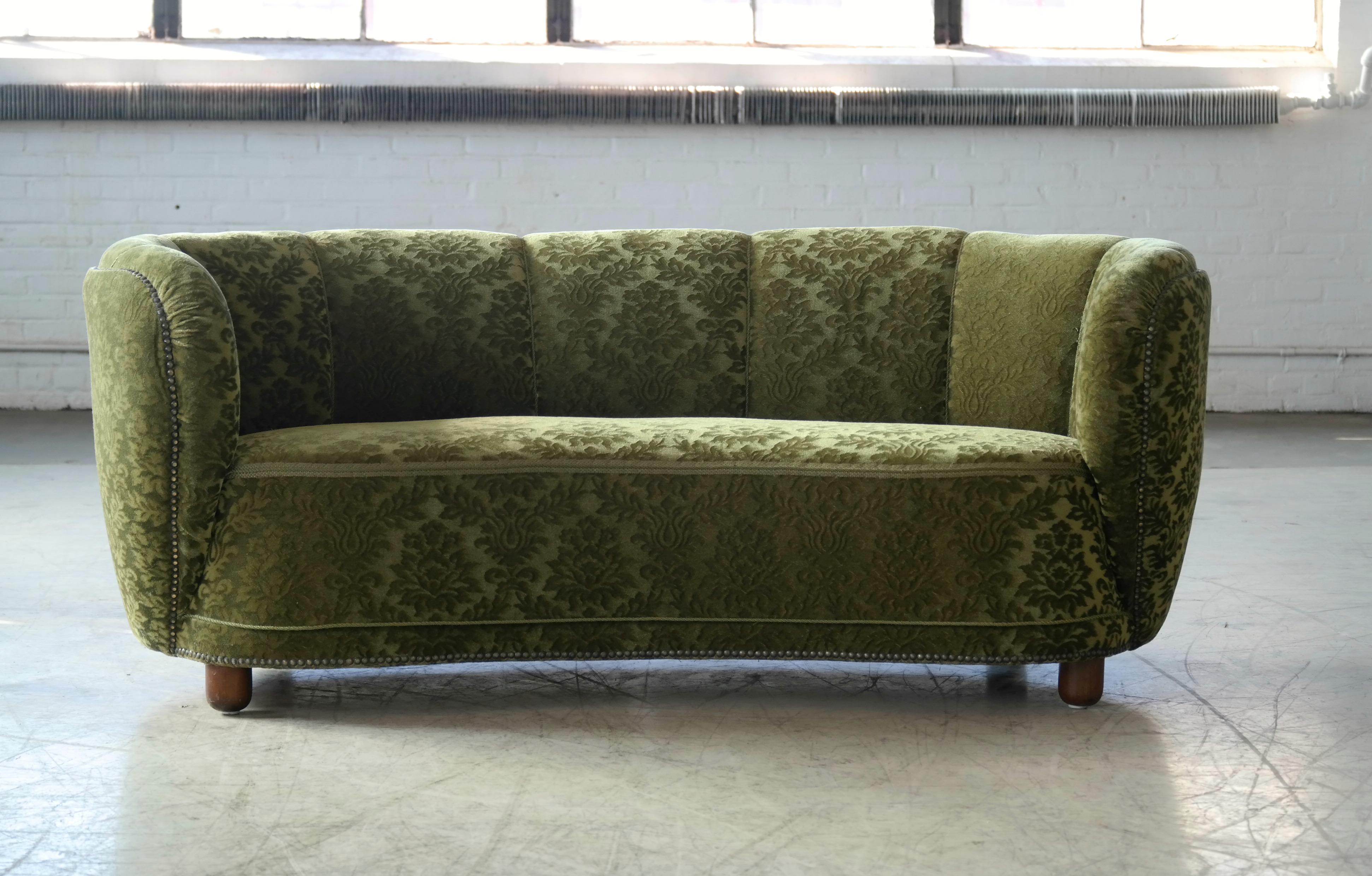 Beautiful and very elegant 1940s curved three-seat sofa in green velvet fabric. The sofa has springs in the seat and the backrest and the cushions are nice and firm and the sofa very sturdy. The sofa has been re-upholstered in the past and the